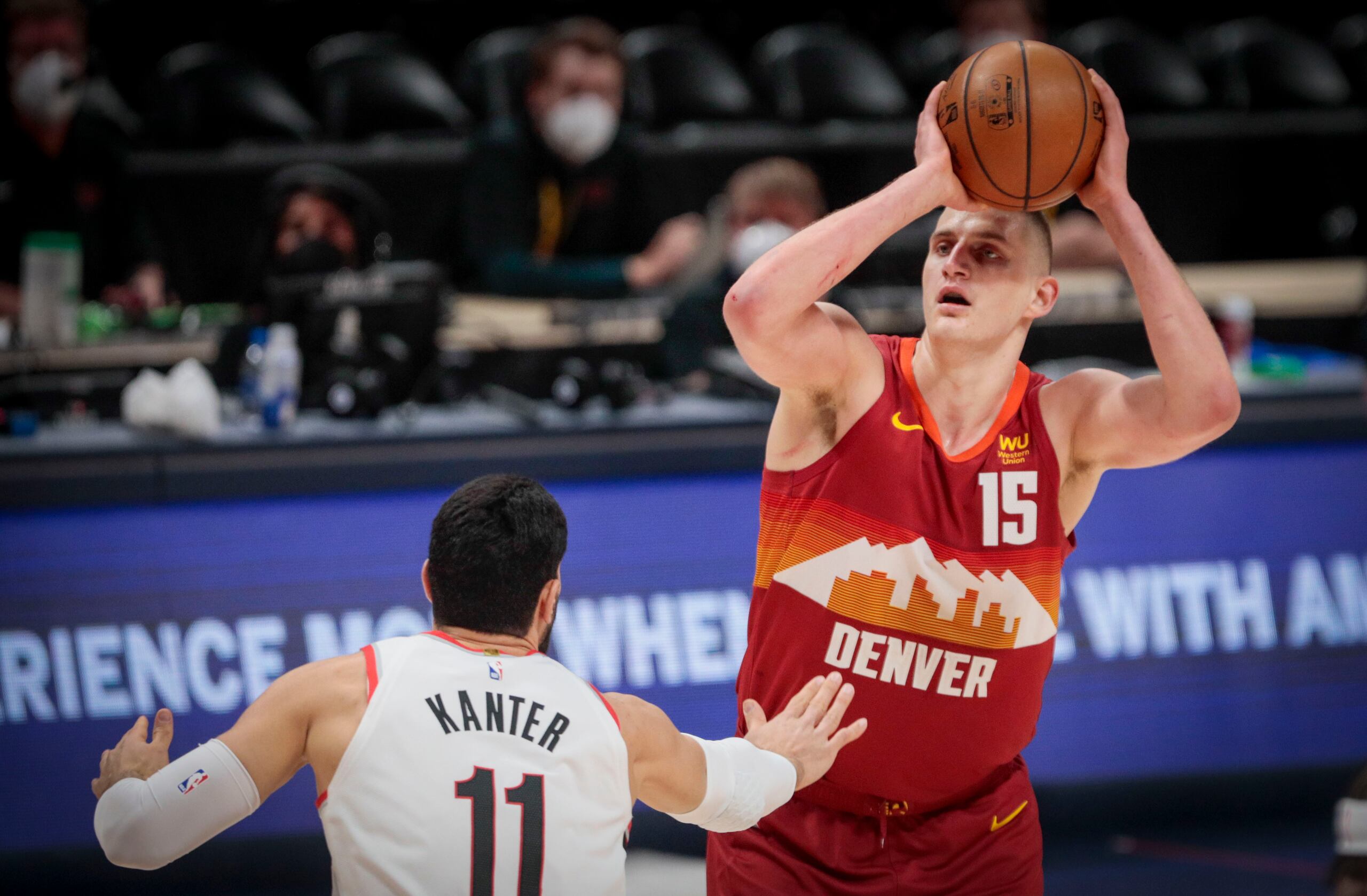 El jugador de los Nuggets de Denver Nikola Jokic (15) lanza por encima del jugador de los Trail Blazers de Portland Enes Kanter (11).