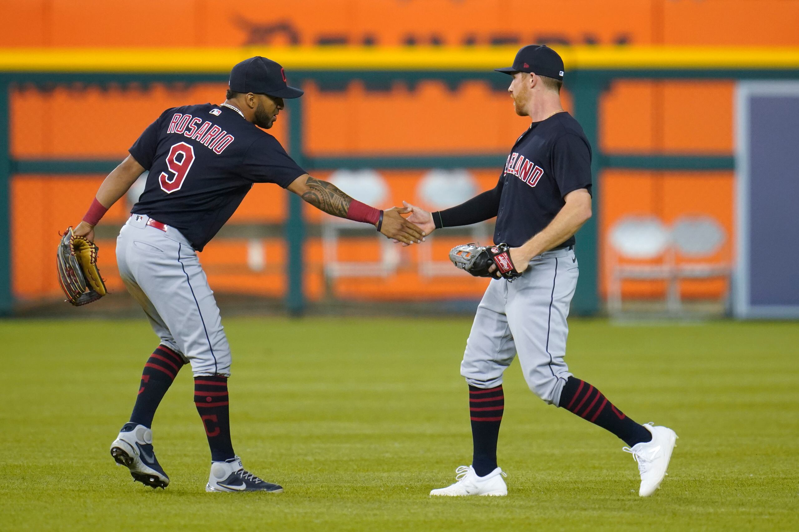 El jardinero de los Indians, Eddie Rosario, a la izquierda, felicita a su compañero Jordan Luplow luego de su espectacular atrapada para finalizar el partido.