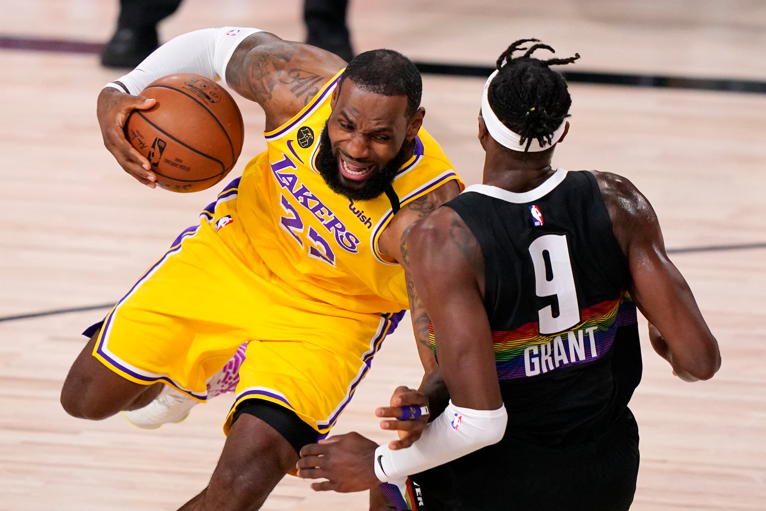 LeBron James maneja el balón contra Jerami Grant en la primera mitad del cuarto encuentro de la final del Oeste entre los Lakers y los Nuggets.