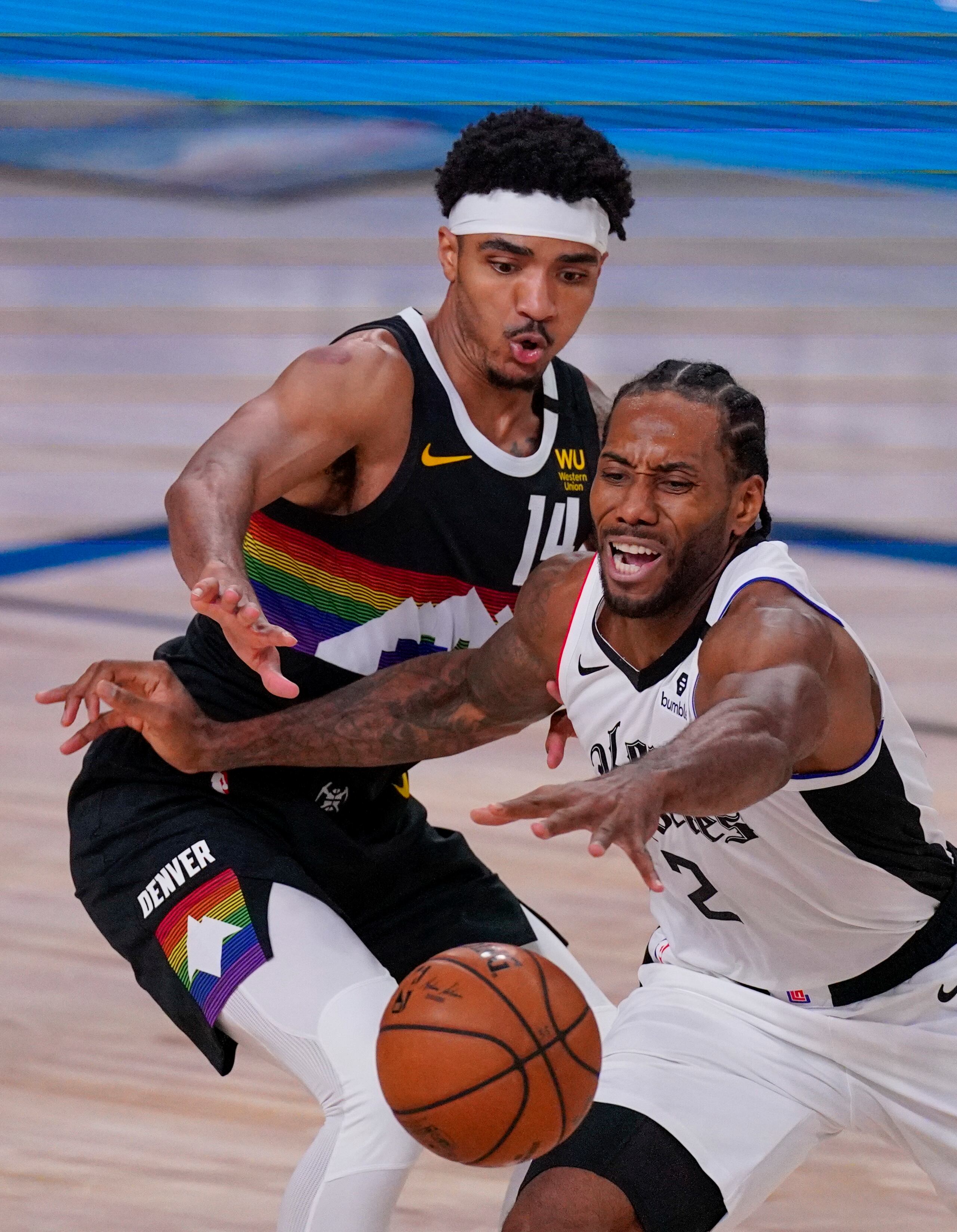 Kawhi Leonard, de los Clippers, trata de recuperar un balón que casi se le escapa ante la defensa de Gary Harris (14), de Denver.