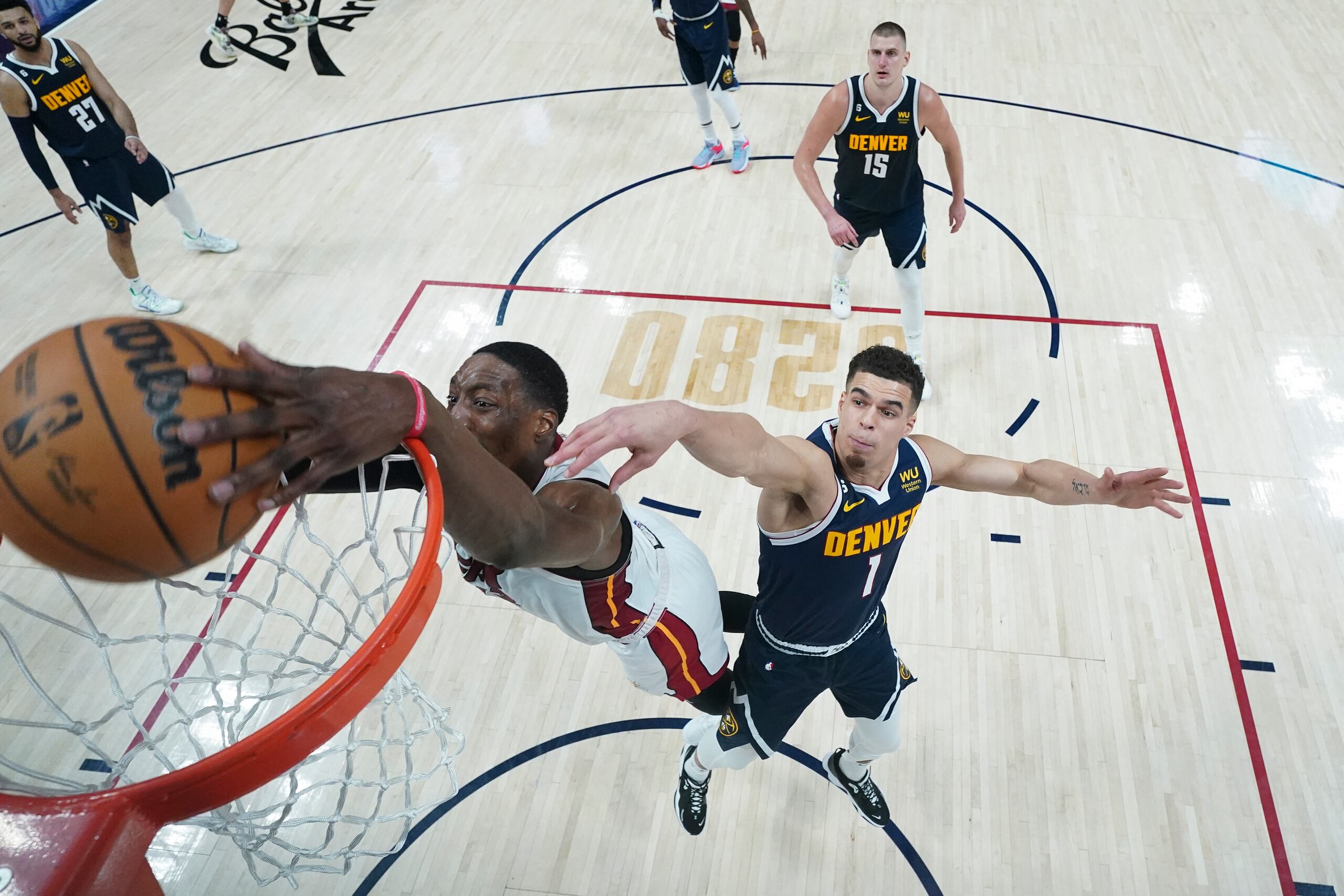 El centro del Heat, Bam Adebayo, siembra un balón frente a la defensa de Michael Porter Jr. de los Nuggets durante la remontada del Heat en el juego del domingo.