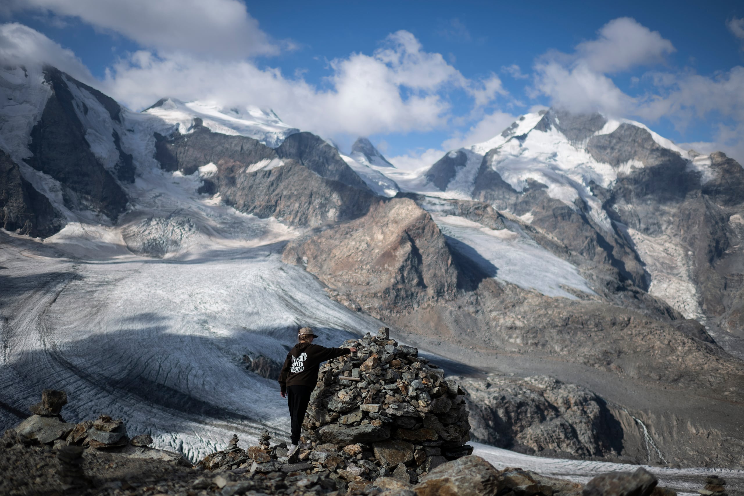 Una persona posa frente al grupo de montañas Bernina, en Pontresina, Suiza, el miércoles 10 de agosto de 2022. (Gian Ehrenzeller/Keystone vía AP)