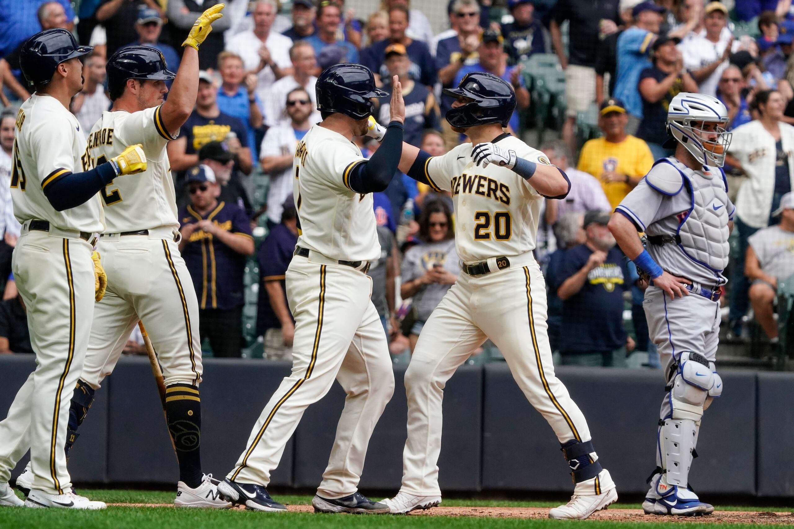 Mike Brosseau es felicitado luego de conectar el grand slam que encaminó a Milwaukee a la victoria.