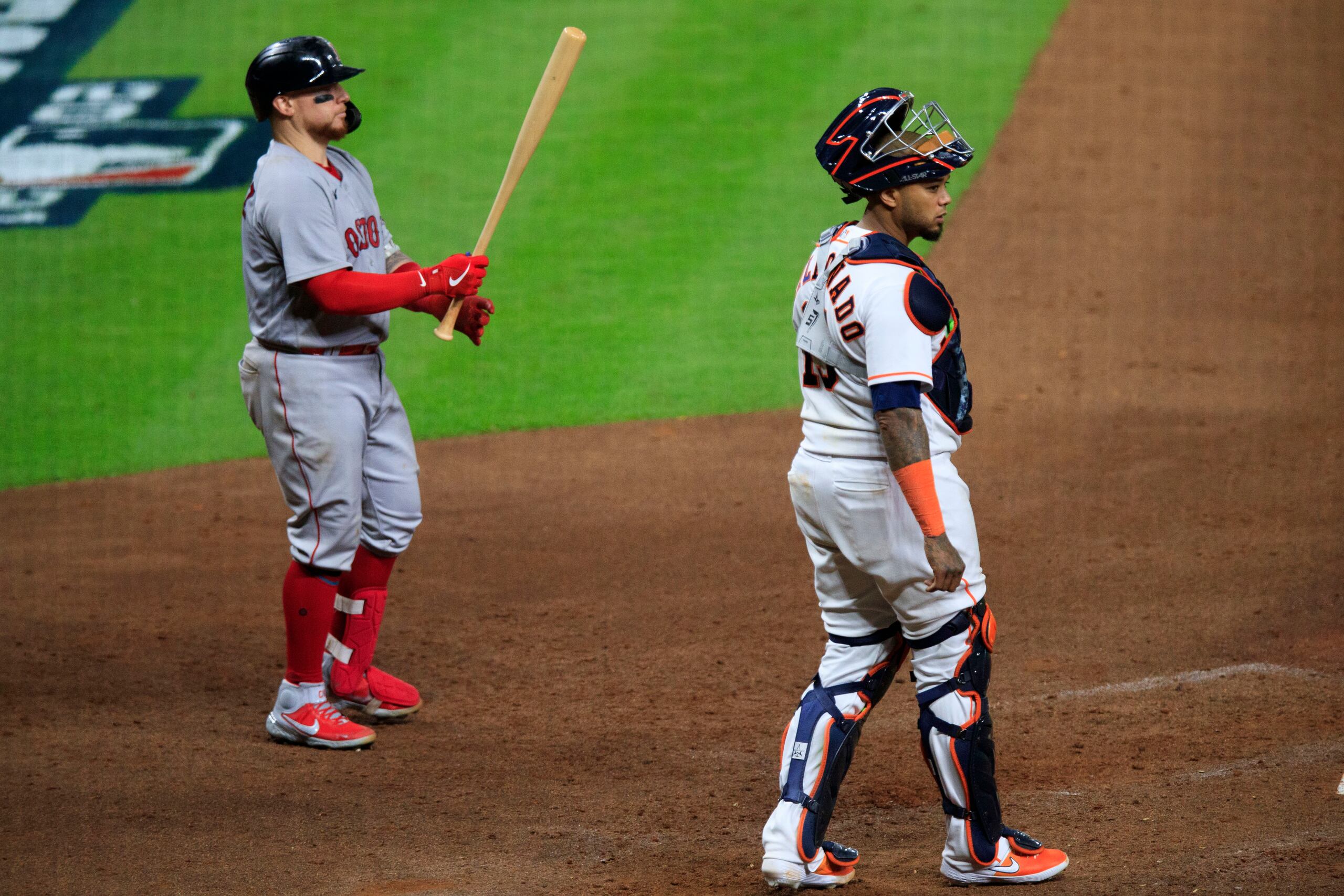 Christian Vázquez, preparándose para batear, y Martín Maldonado, con los aperos puestos, son amigos fuera del terreno y siente orgullo de estar enfrentándose en la Serie de Campeonato de la Liga Americana.