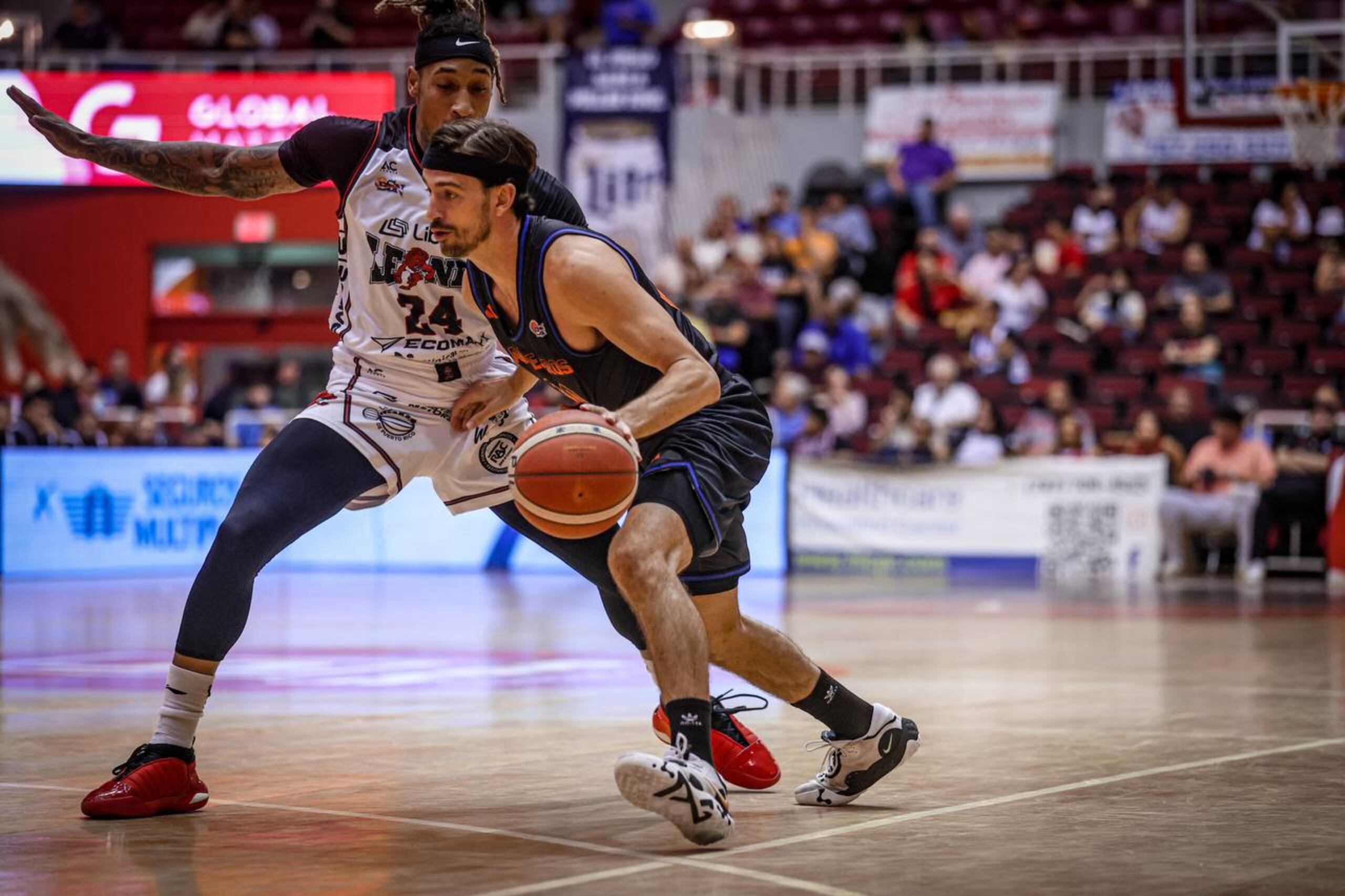 David Stockton, de los Cangrejeros de Santurce, es defendido muy de cerca por Jared Ruiz, de los Leones de Ponce, durante el choque del miércoles en el Pachín Vicens.