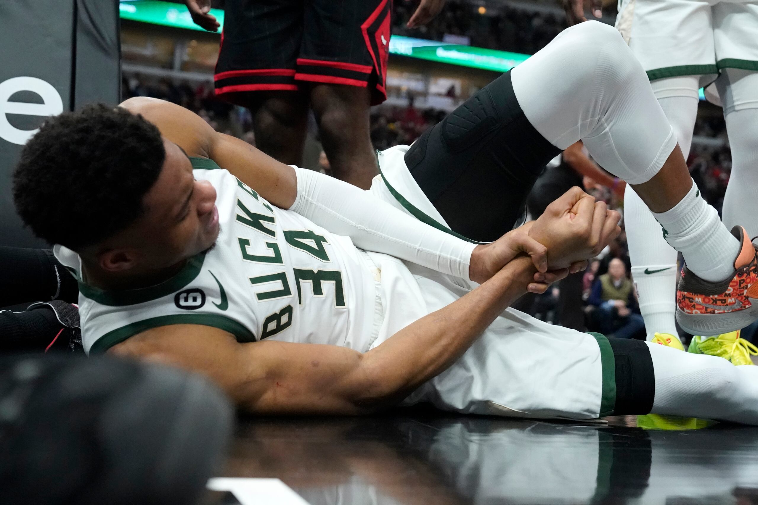 Giannis Antetokounmpo, de los Bucks de Milwaukee, se agarra la muñeca derecha tras lastimarse en el partido del jueves ante los Bulls de Chicago.