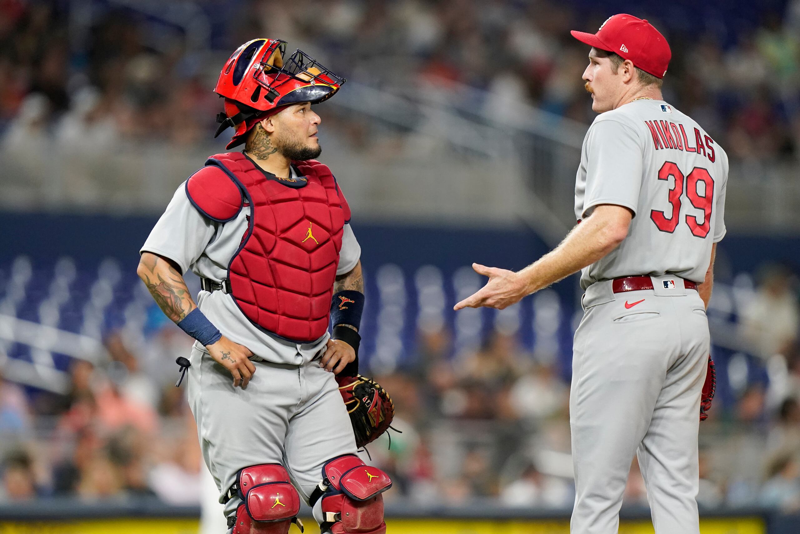 El receptor boricua Yadier Molina sostiene una conversación con el lanzador Miles Mikolas durante la cuarta entrada del encuentro del jueves en Miami, en el que Molina, Mikolas y los Cardinals dominaron a los Marlins.