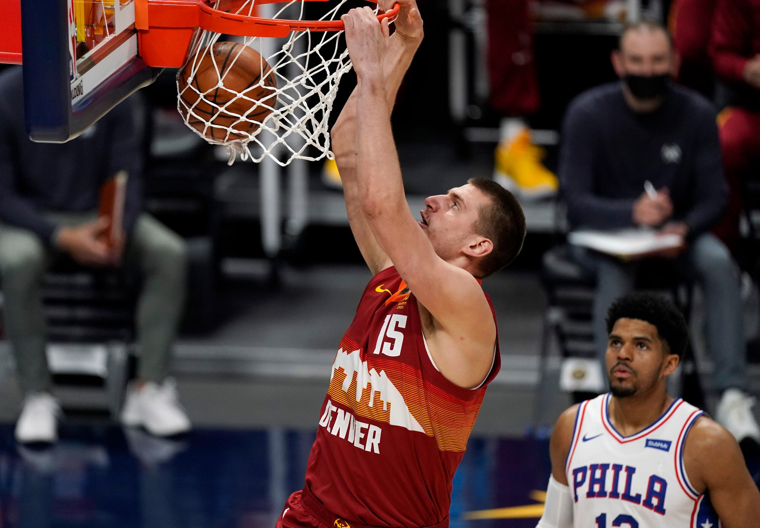 El pivot de los Nuggets de Denver Nikola Jokic donquea el balón mientras lo observa Tobias Harris de los 76ers de Filadelfia.