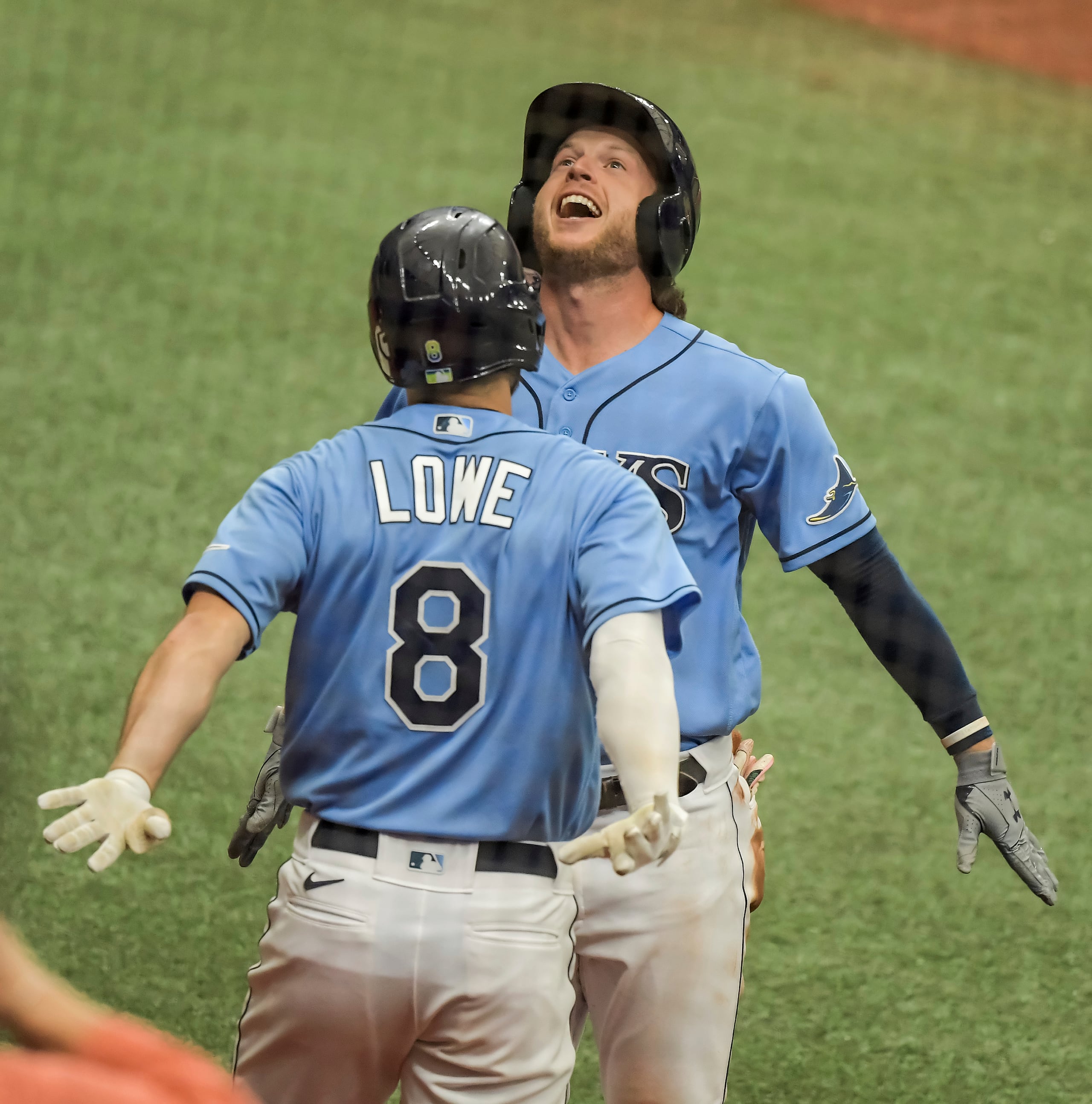 Brandon Lowe de los Rays de Tampa Bay celebra con Brett Phillips luego de que éste último pego un jonrón solitario en la quinta entrada contra los Filis de Filadelfia.