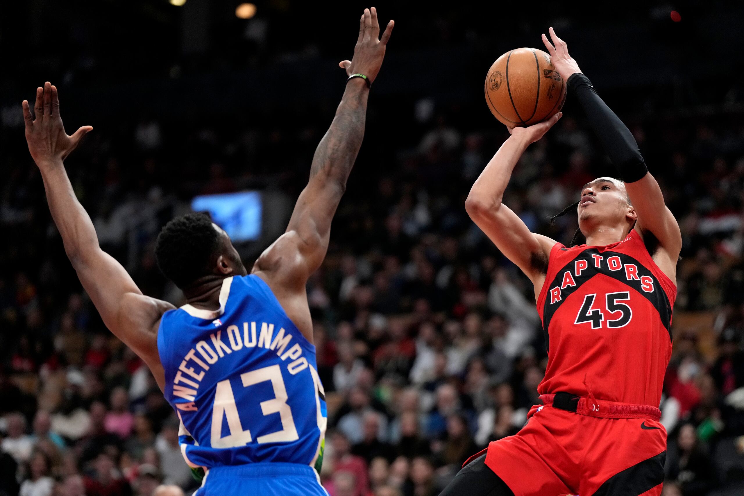 Dalano Banton (45) de los Raptors de Toronto dispara al aro ante Thanasis Antetokounmpo (43) de los Bucks de Milwaukee, el domingo 9 de abril de 2023. (Frank Gunn/The Canadian Press vía AP)