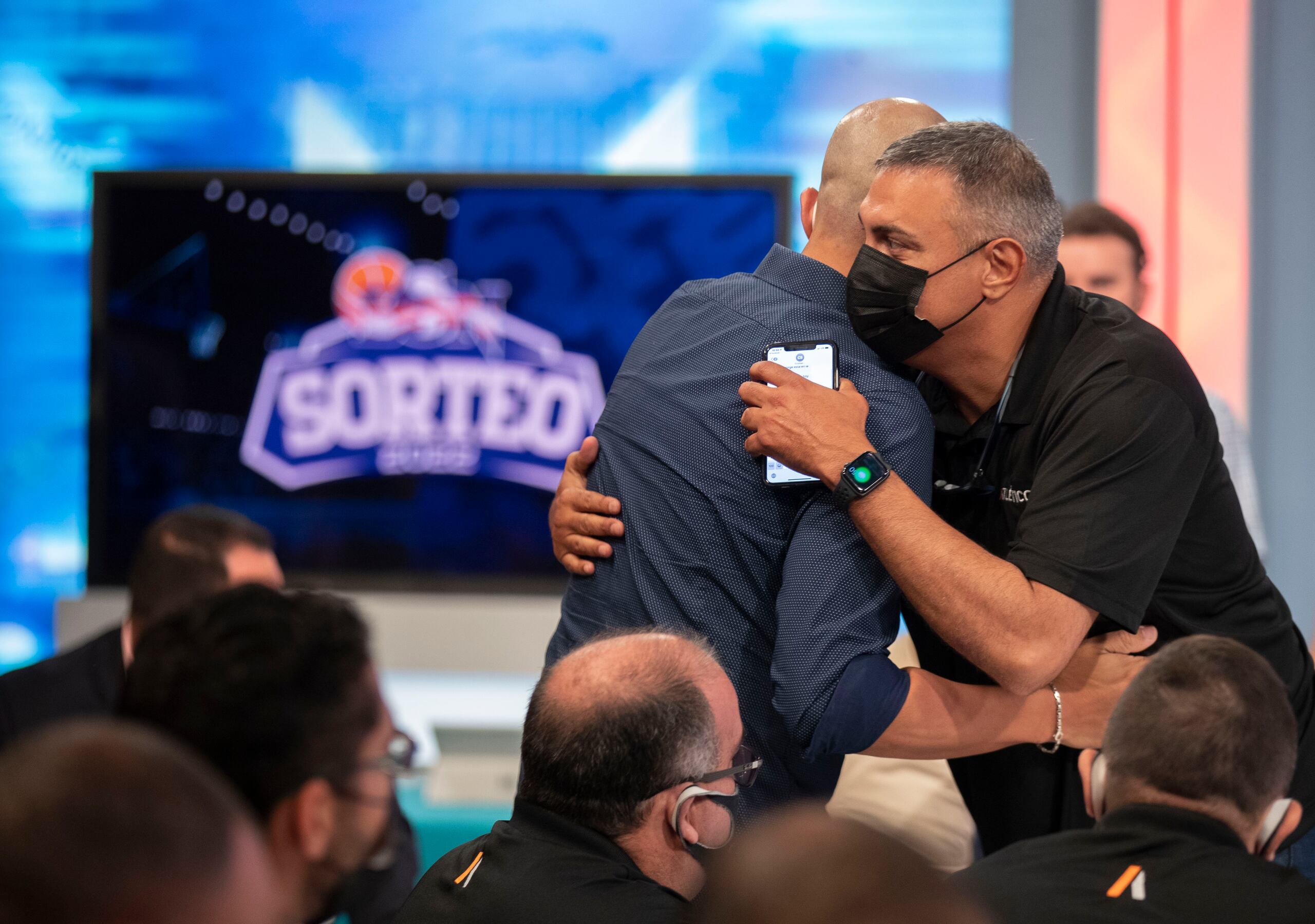 Eddie Casiano, de frente, abraza a su sucesor al frente del Equipo Nacional, Nelson Colón.