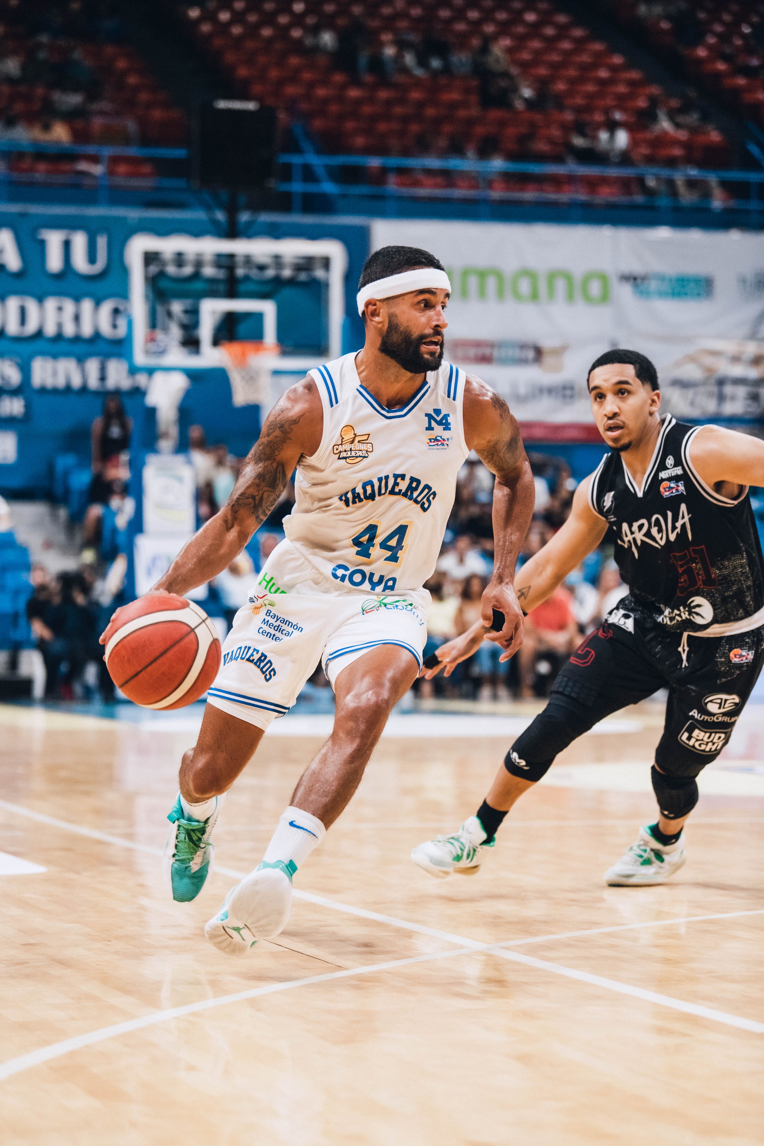 El defensa de los Vaqueros de Bayamón, Javier Mojica, avanza con el balón mientras es observado por Tremont Waters, de los Gigantes de Carolina.