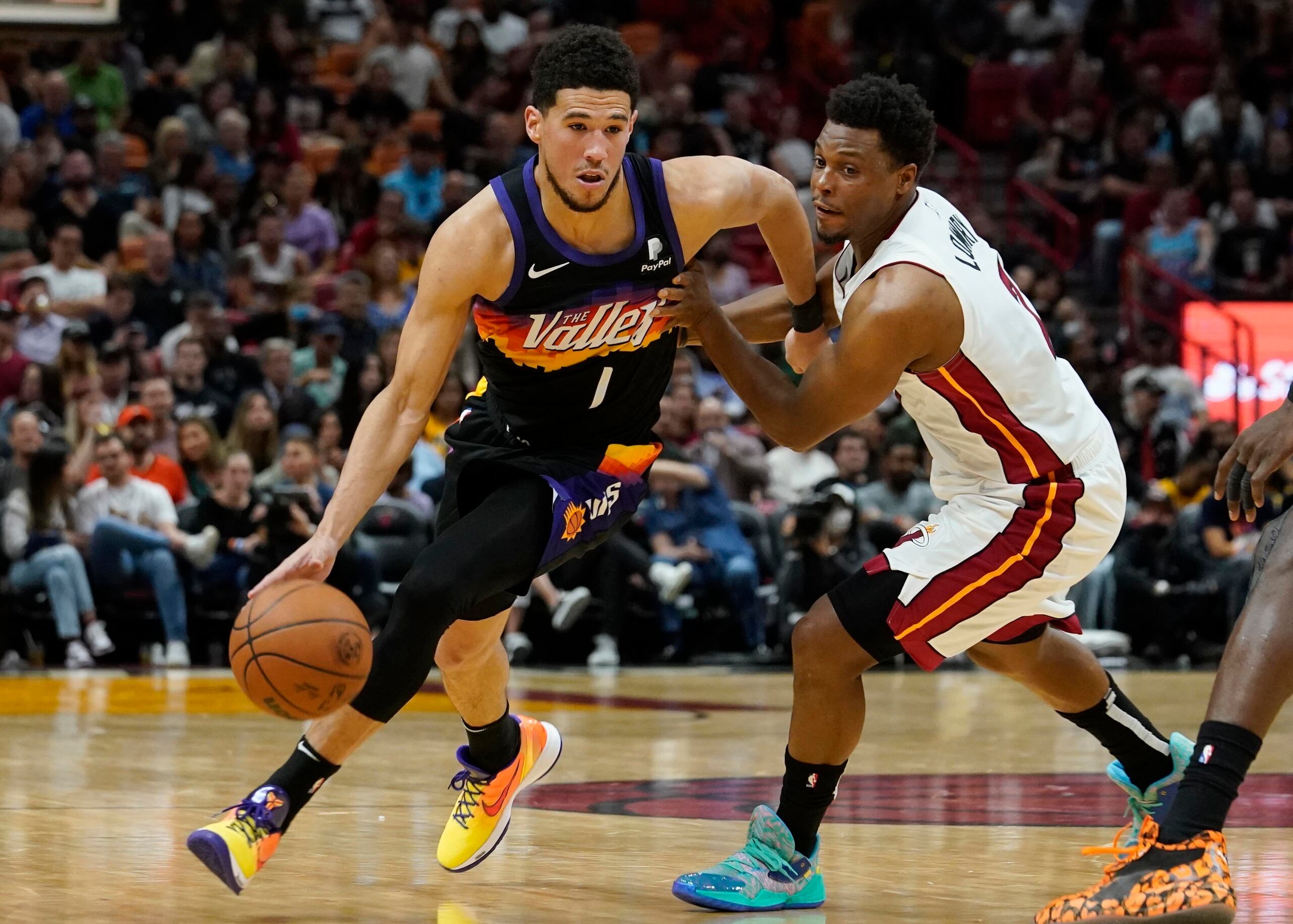 Devin Booker, de los Suns de Phoenix, elude a Kyle Lowry, del Heat de Miami, en el encuentro del miércoles.