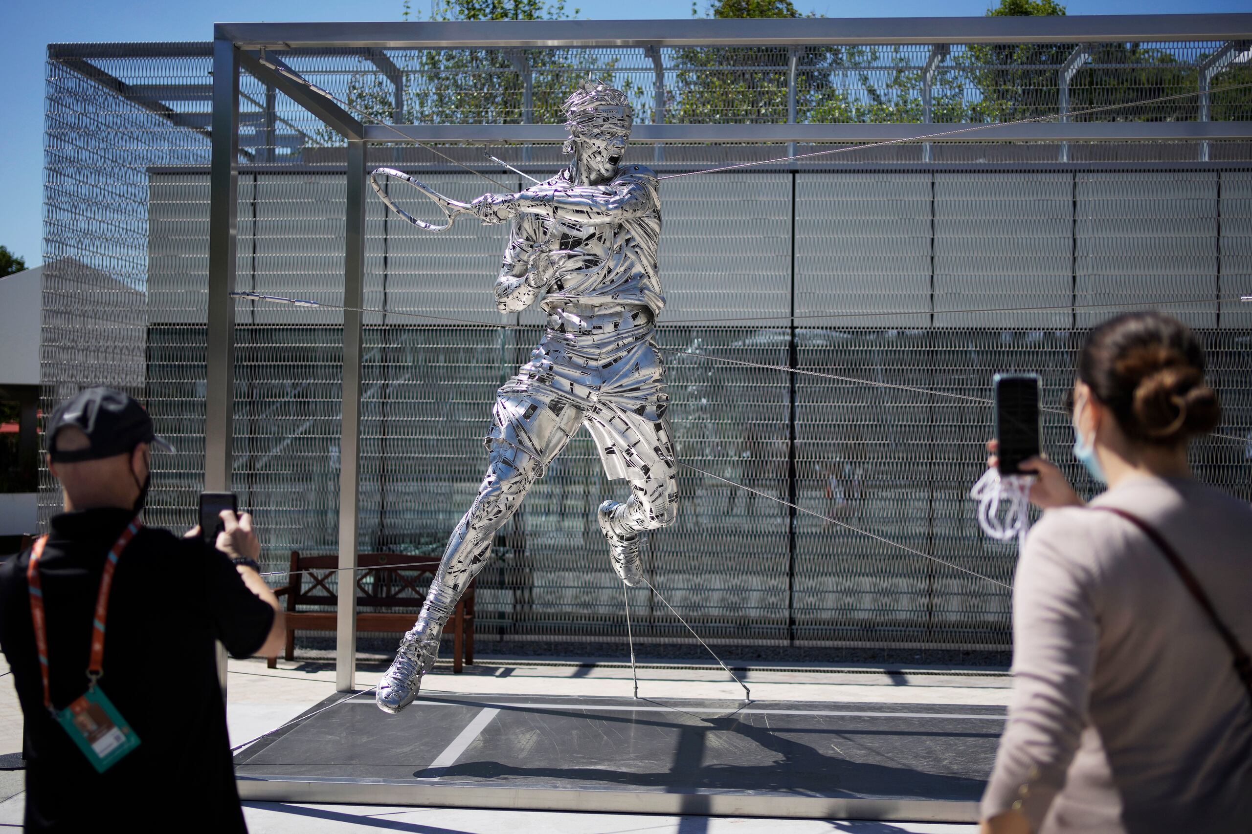 Un grupo de espectadores toma fotos de una nueva estatua de Rafael Nadal en Roland Garros, en París.