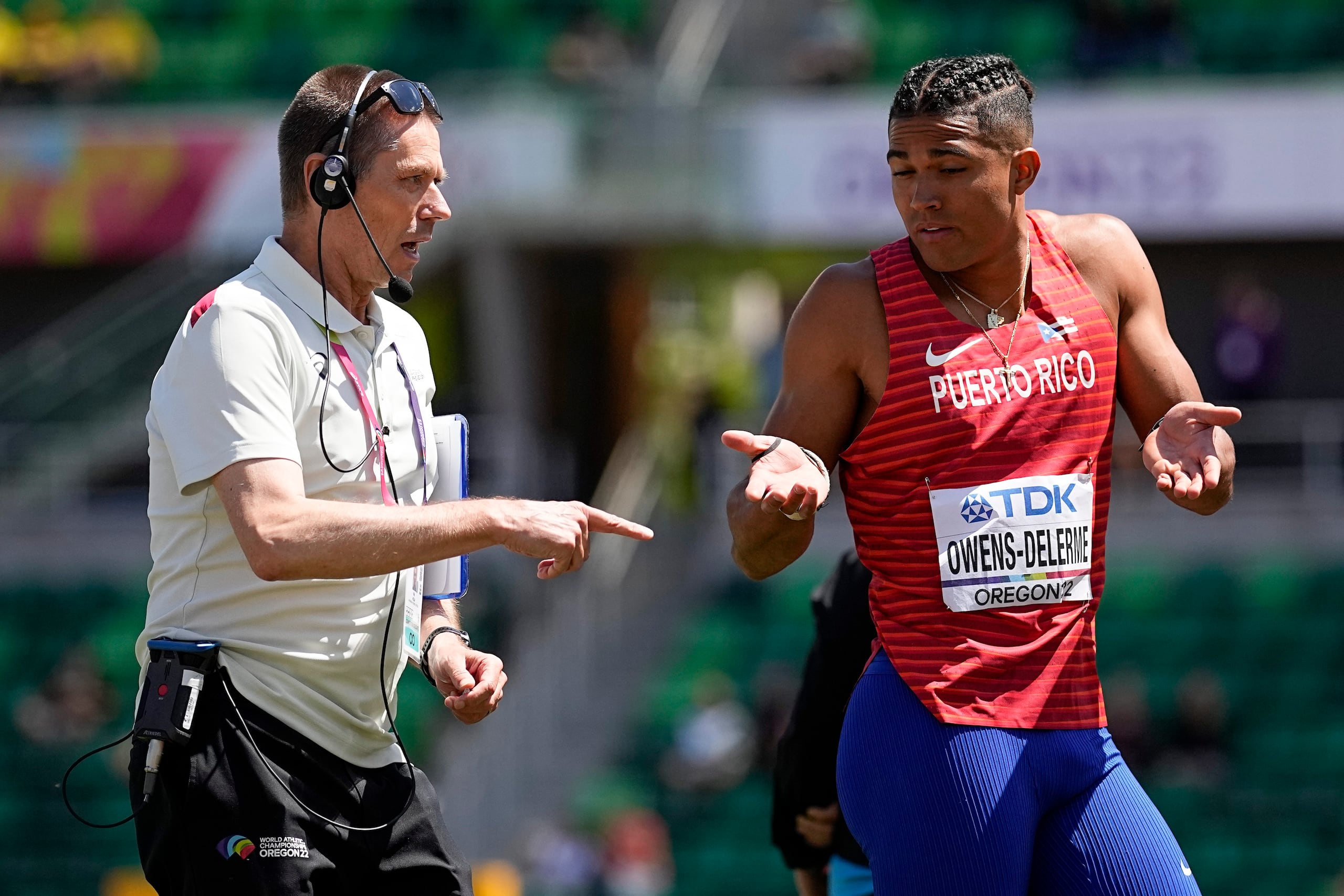 Ayden Owens-Delerme, de Puerto Rico, conversa con un oficial durante uno de los eventos en los que participó durante su gran jornada del sábado en el Mundial de Atletismo.