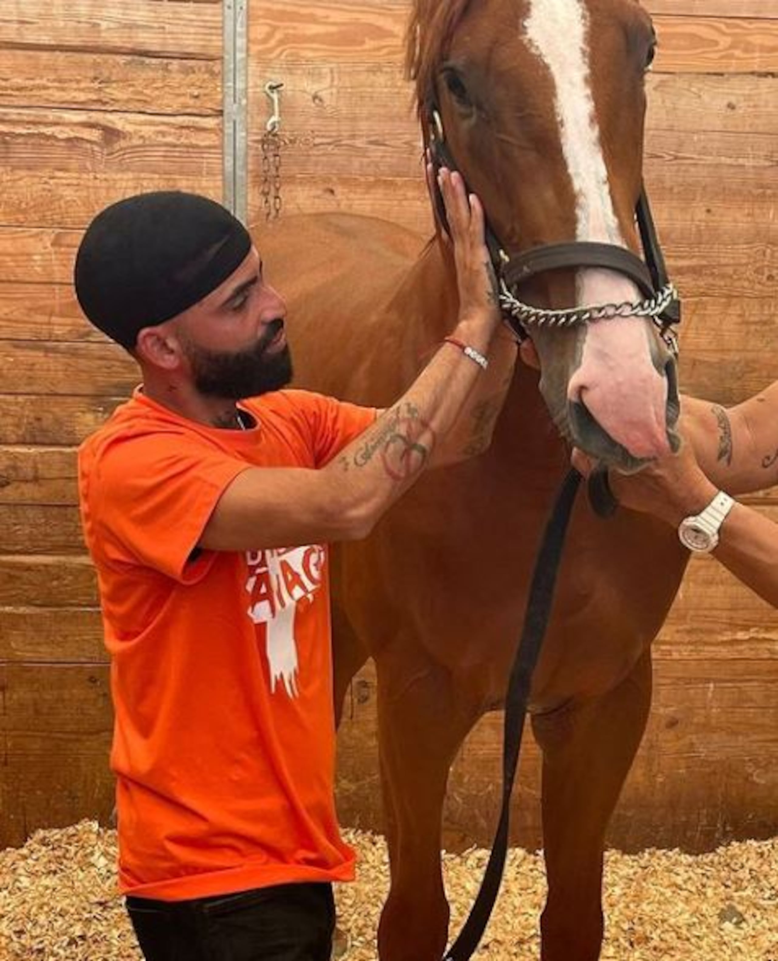 Arcángel acaricia aquí al caballo que compró para honrar la memoria de su hermano, quien era amante de los animales.