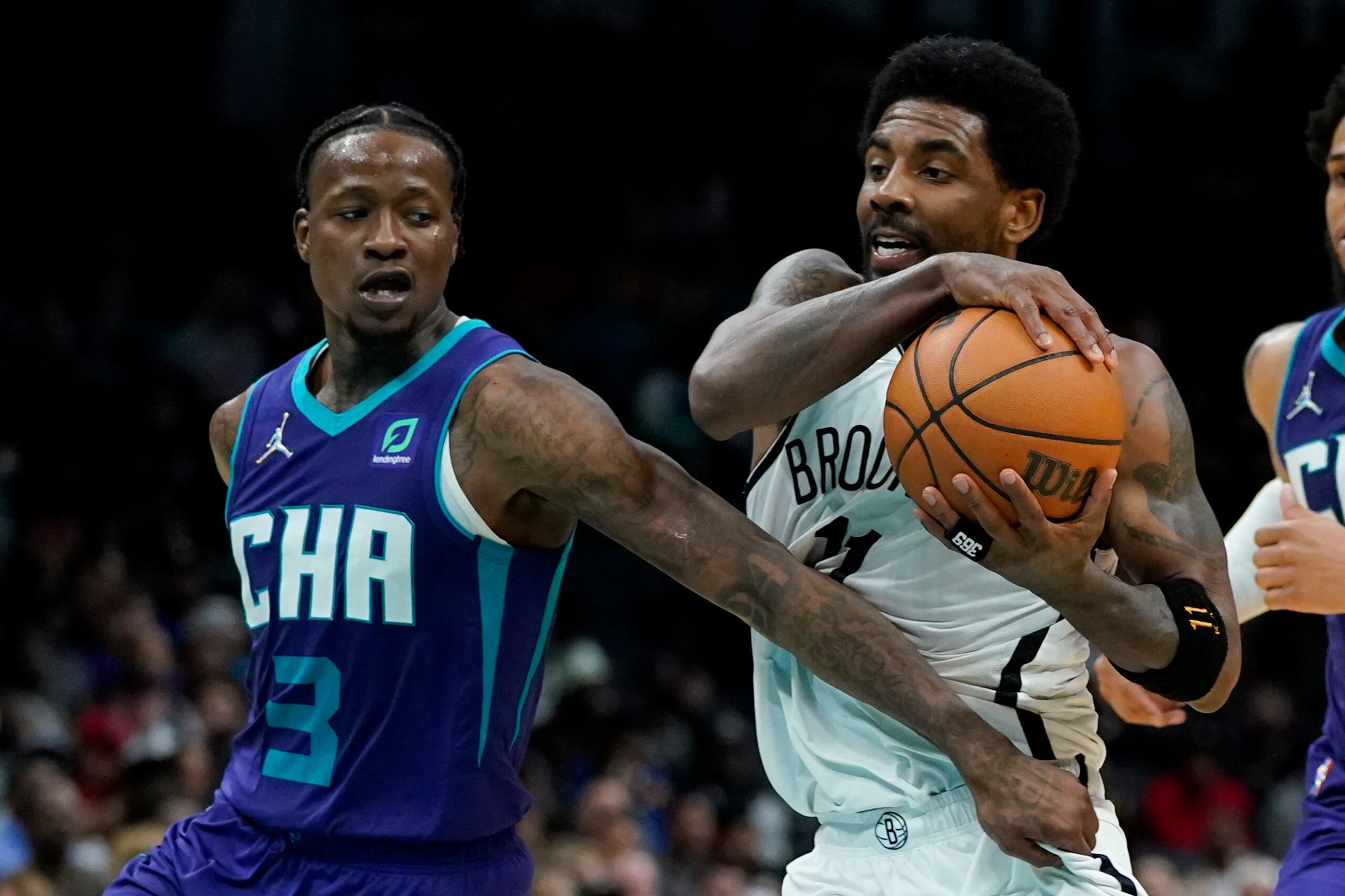 El defensa de los Hornets de Charlotte, Terry Rozier, intenta agarrar a Kyrie Irving, de los Nets de Brooklyn, durante una penetración escenificada en el encuentro del martes.