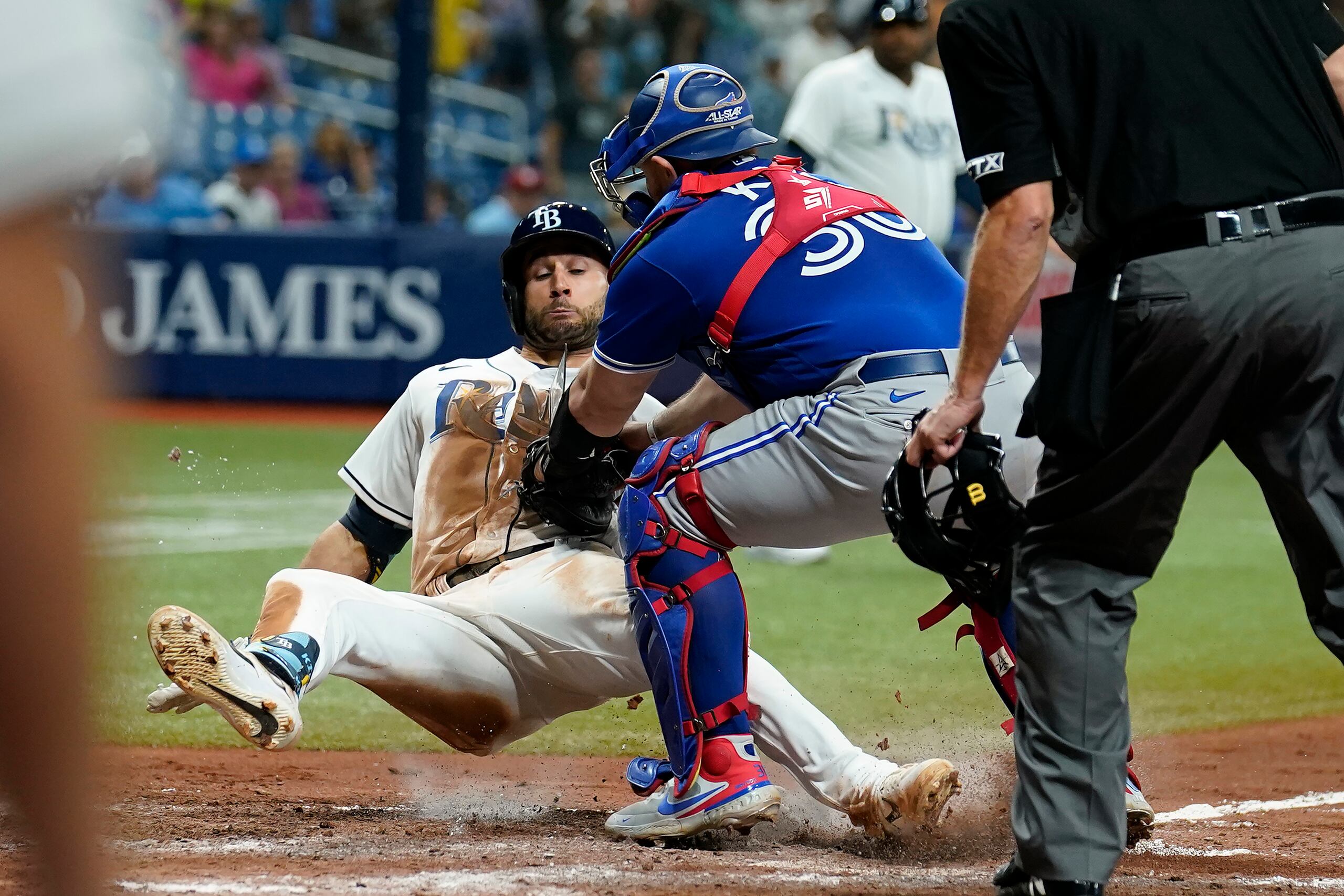 El mexicano Alejandro Kirk, de los Azulejos de Toronto, pone out a Kevin Kiermaier, de los Rays de Tampa Bay, en el juego del lunes 20 de septiembre de 2021. En la jugada perdió una tarjeta de apuntes que lleva en su muñequera y el corredor se la llevó a la banca de su equipo.