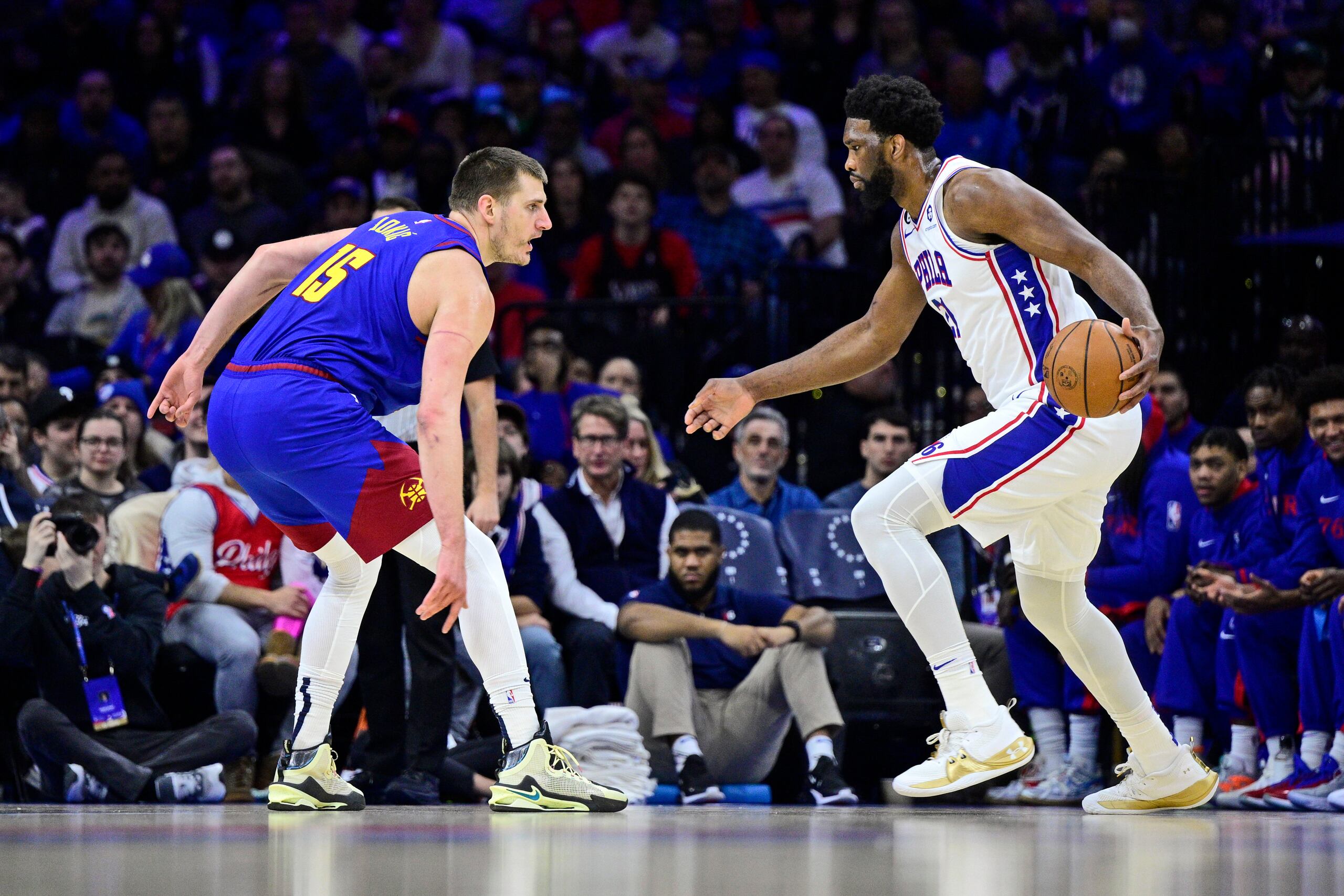 El canastero de los Sixers de Filadelfia, Joel Embiid, con el balón, busca iniciar una penetración contra Nikola Jokic, de los Nuggets de Denver.