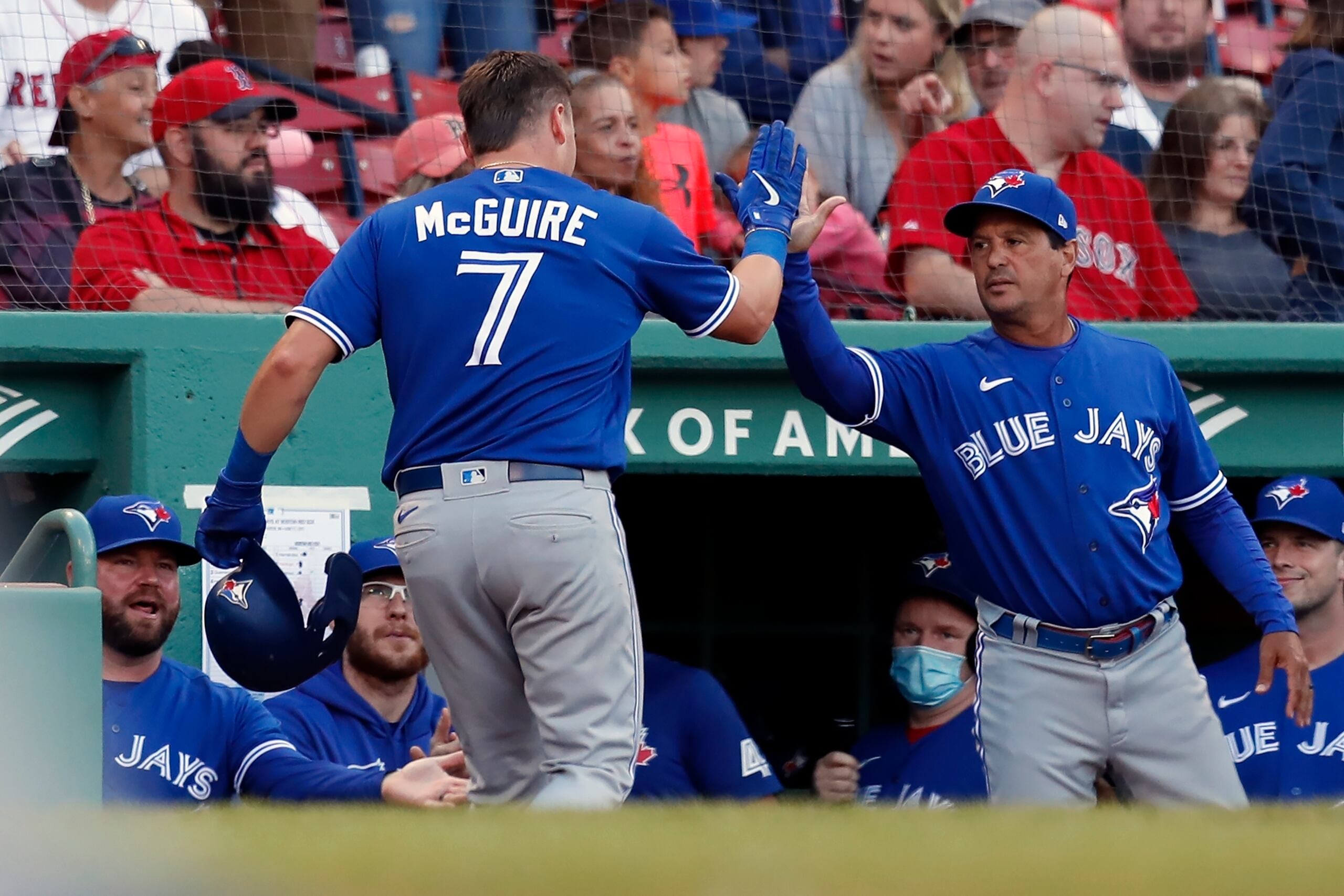 Reese McGuire, de los Blue Jays, regresa al dugout tras pegar uno de los cinco jonrones de Toronto y recibe el saludo del dirigente boricua Charlie Montoyo.