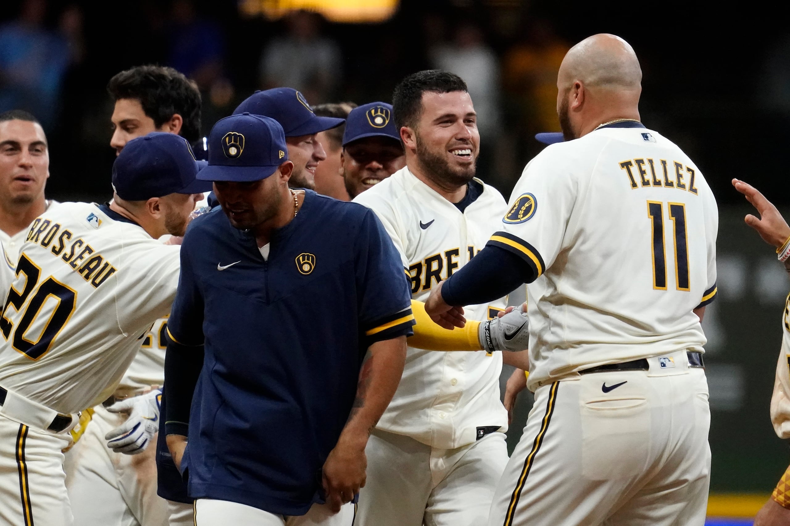 El jugador de los Cerveceros de Milwaukee, Víctor Caratini, segundo por la derecha, es felicitado por sus compañeros tras su sencillo de dos carreras en el 11mo inning.