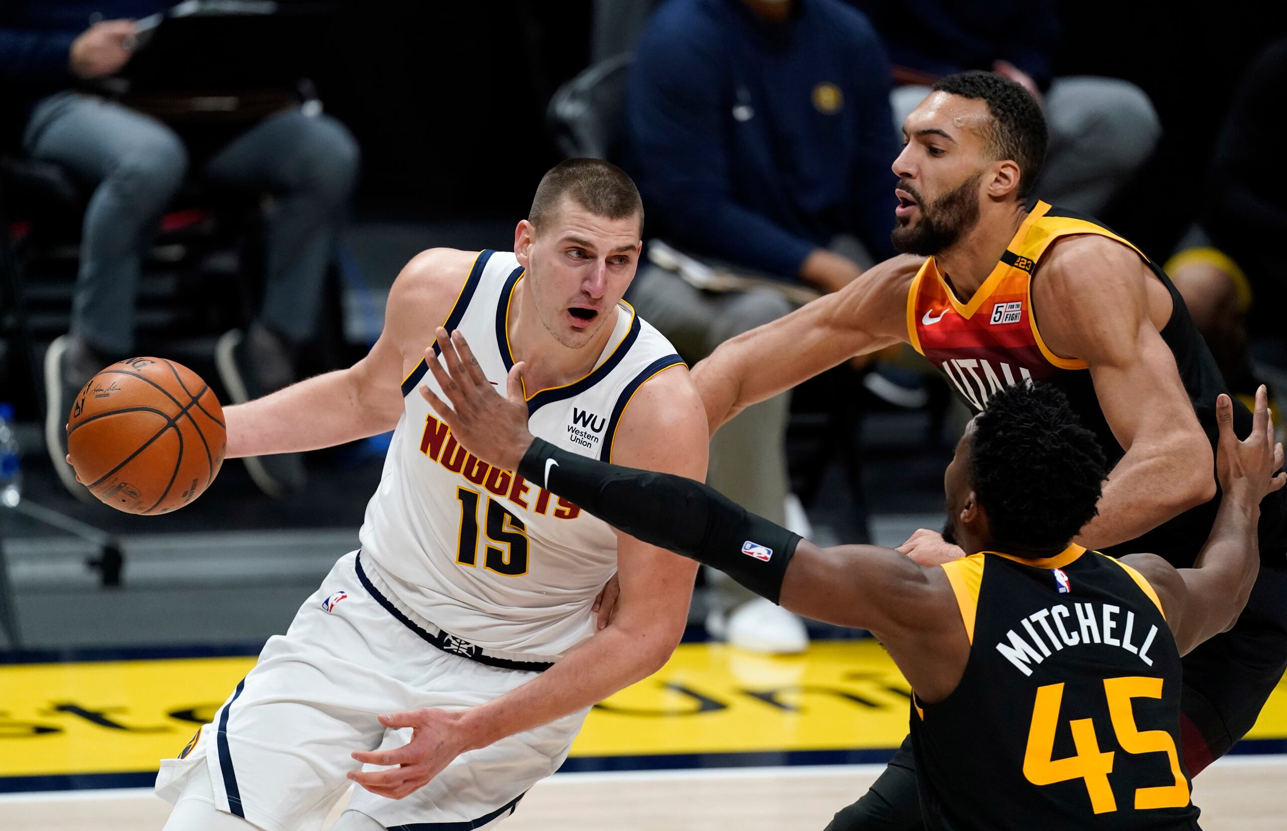 Nikola Jokic, izquierda, de los Nuggets de Denver, se enfila a la canasta ante Donovan Mitchell (45) y Rudy Gobert, del Jazz de Utah, en duelo de la NBA el domingo 31 de enero de 2021, en Denver.