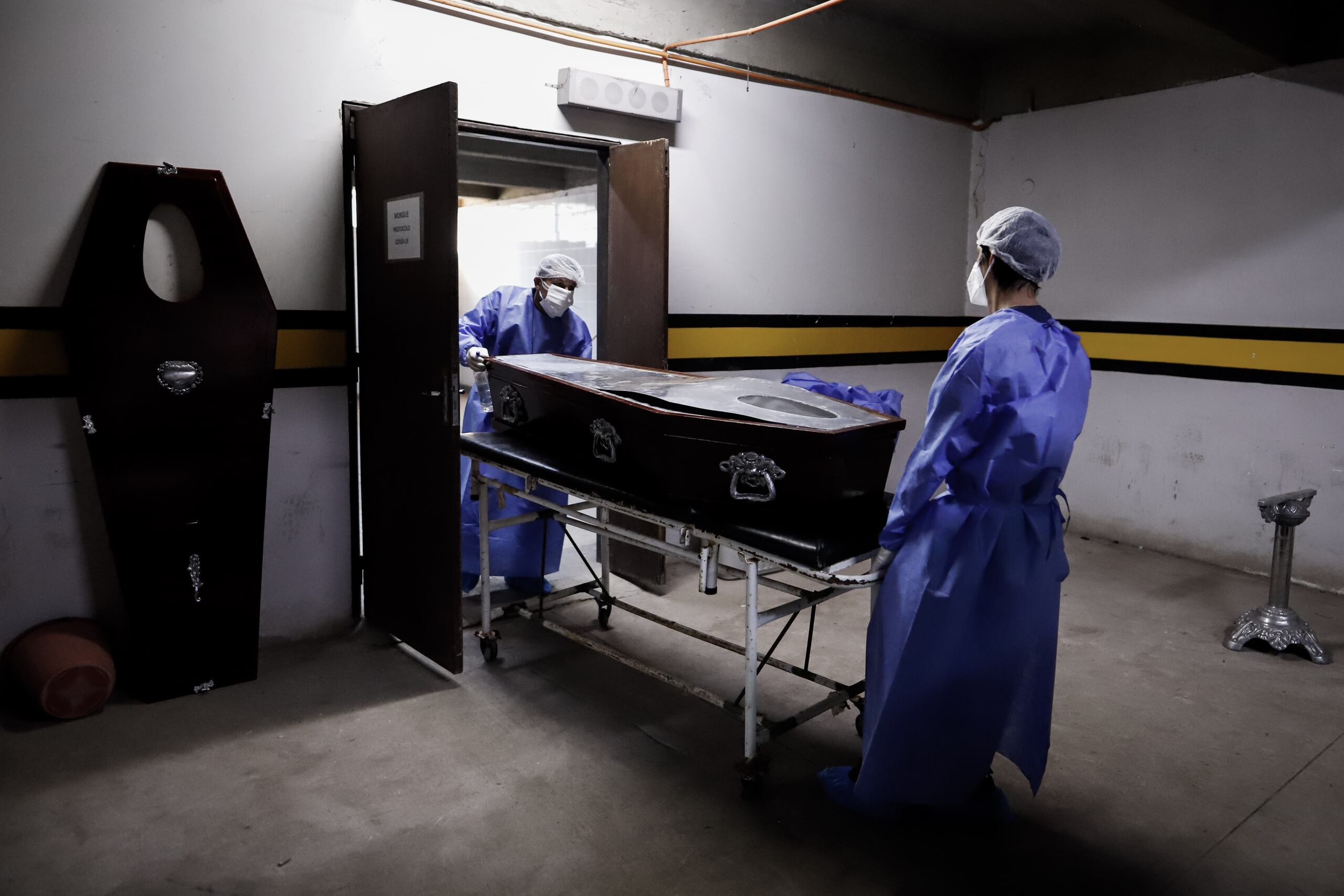 Personal de una funeraria realiza el levantamiento de un cadáver, en una fotografía de archivo. EFE/Nathalia Aguilar
