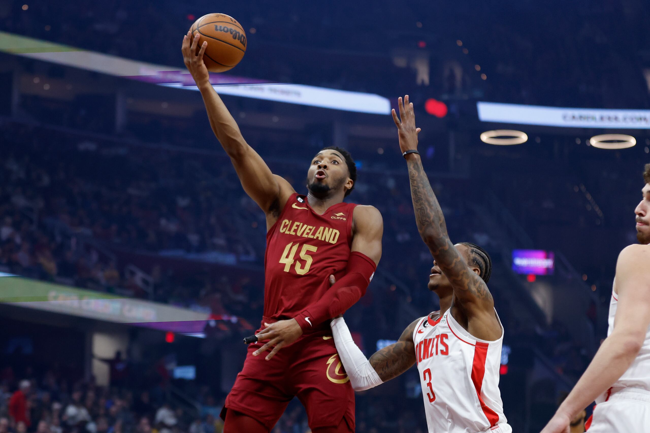 Donovan Mitchell (45), de los Cavaliers de Cleveland, dispara con la marca defensiva de Kevin Porter Jr. (3), de los Rockets de Houston, durante la primera mitad del juego de baloncesto de la NBA, el domingo 26 de marzo de 2023, en Cleveland. (AP Foto/Ron Schwane)