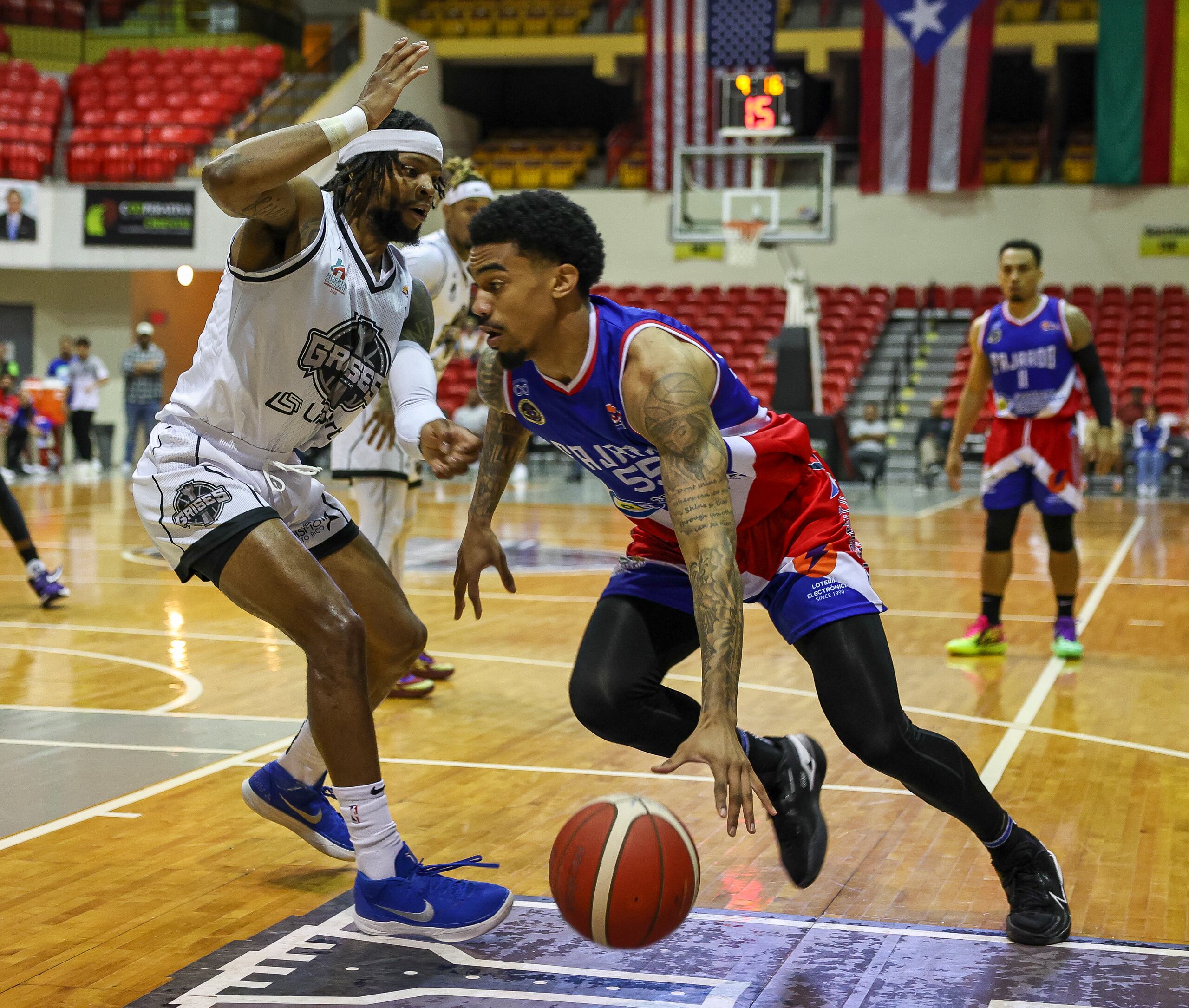 Manny Camper, de los Cariduros de Fajardo, se dispone a atacar el canasto frente a la defensa de Zavier Simpson, de los Grises de Humacao.