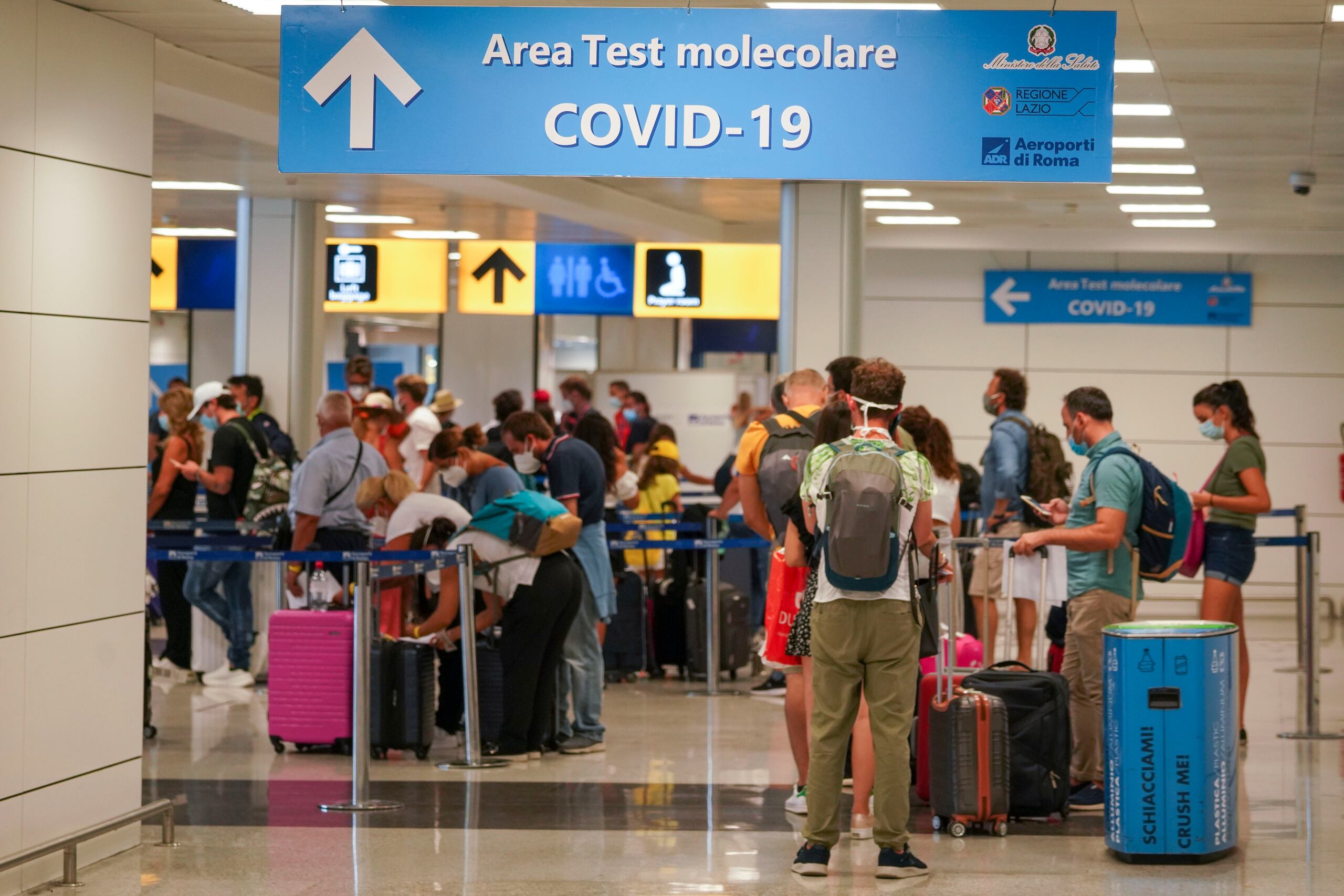 Vacacionistas llegan al Aeropuerto Leonardo da Vinci en Roma, Italia, donde son examinados de inmediato por coronavirus, el domingo 16 de agosto de 2020.