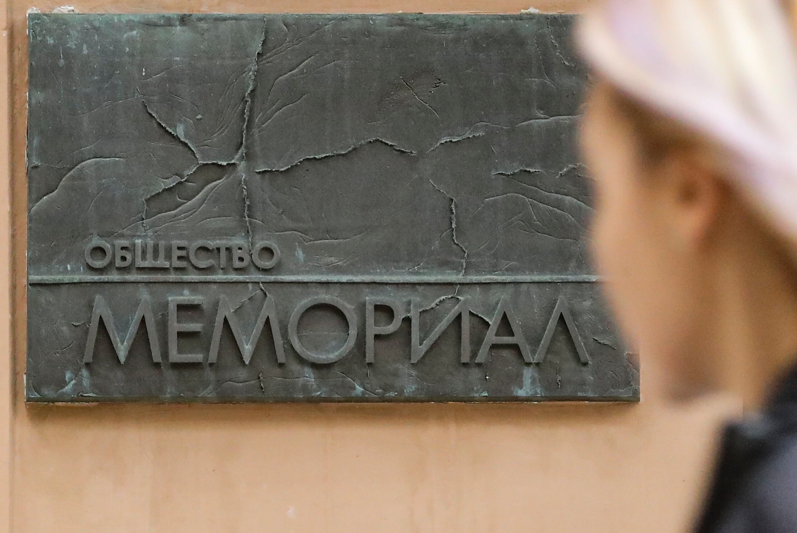 Una mujer pasa frente a un cartel que dice "La sociedad del Memorial" en la entrada de la sede del Centro de Derechos Humanos del Memorial de Moscú este viernes.