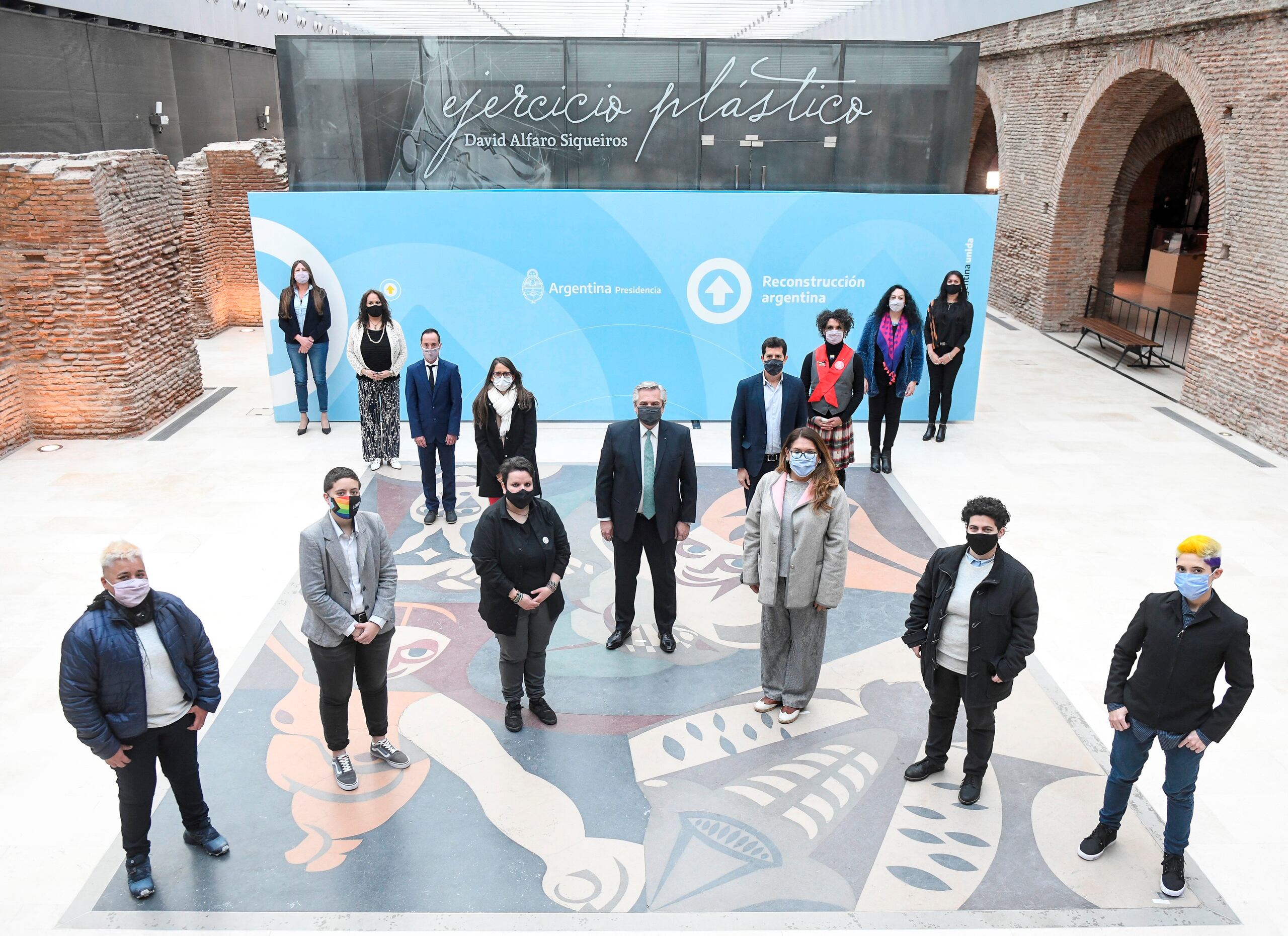 El presidente Alberto Fernández, al centro, junto a otras autoridades y miembros de organismos sociales posan emulando una "x", en el Museo del Bicentenario de la Casa Rosada.