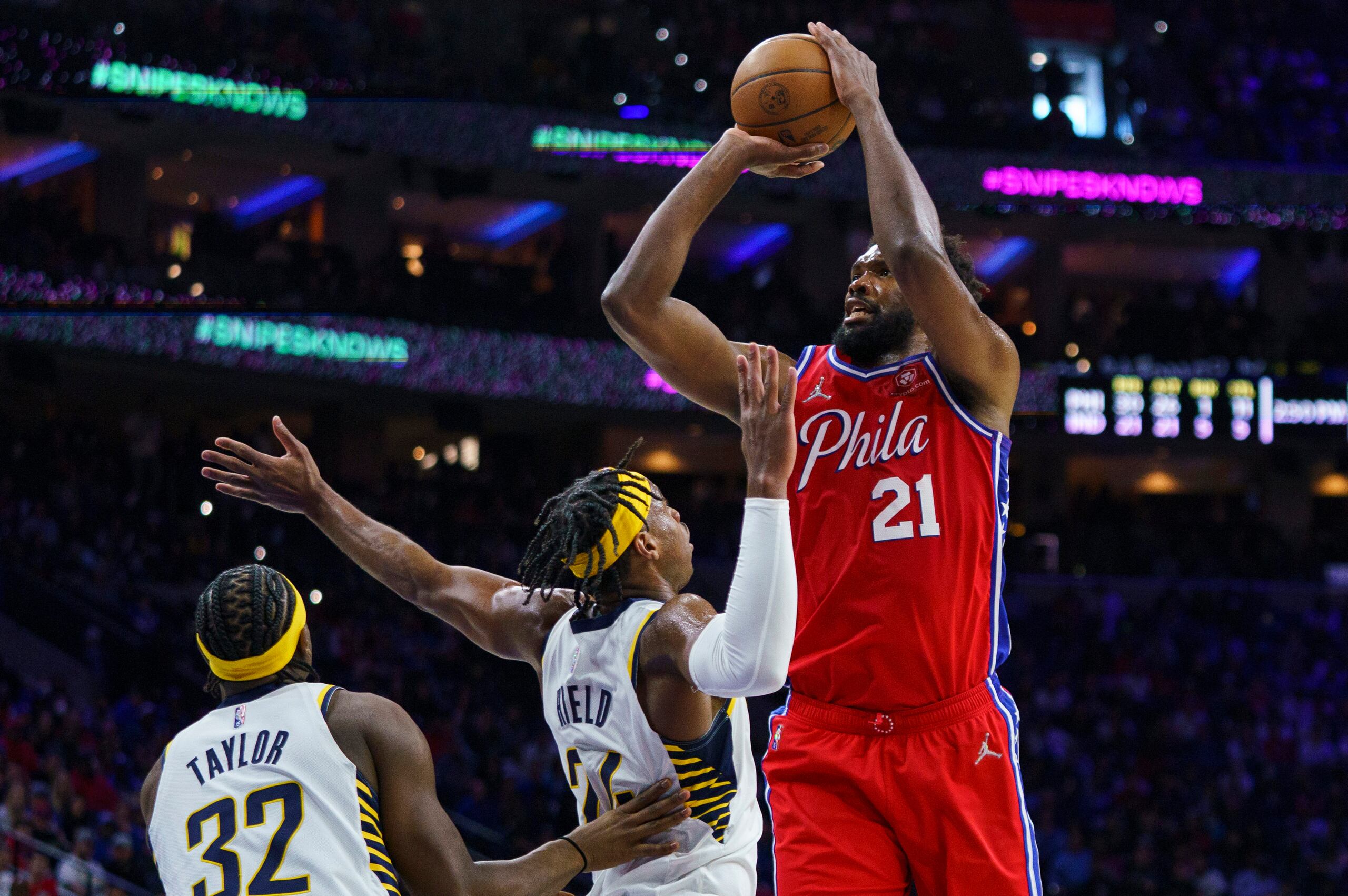 Joel Embiid, de los Sixers de Filadelfia, realiza un disparo sobre Buddy Hield y Terry Taylor (32), de los Pacers de Indiana, durante el encuentro del sábado.