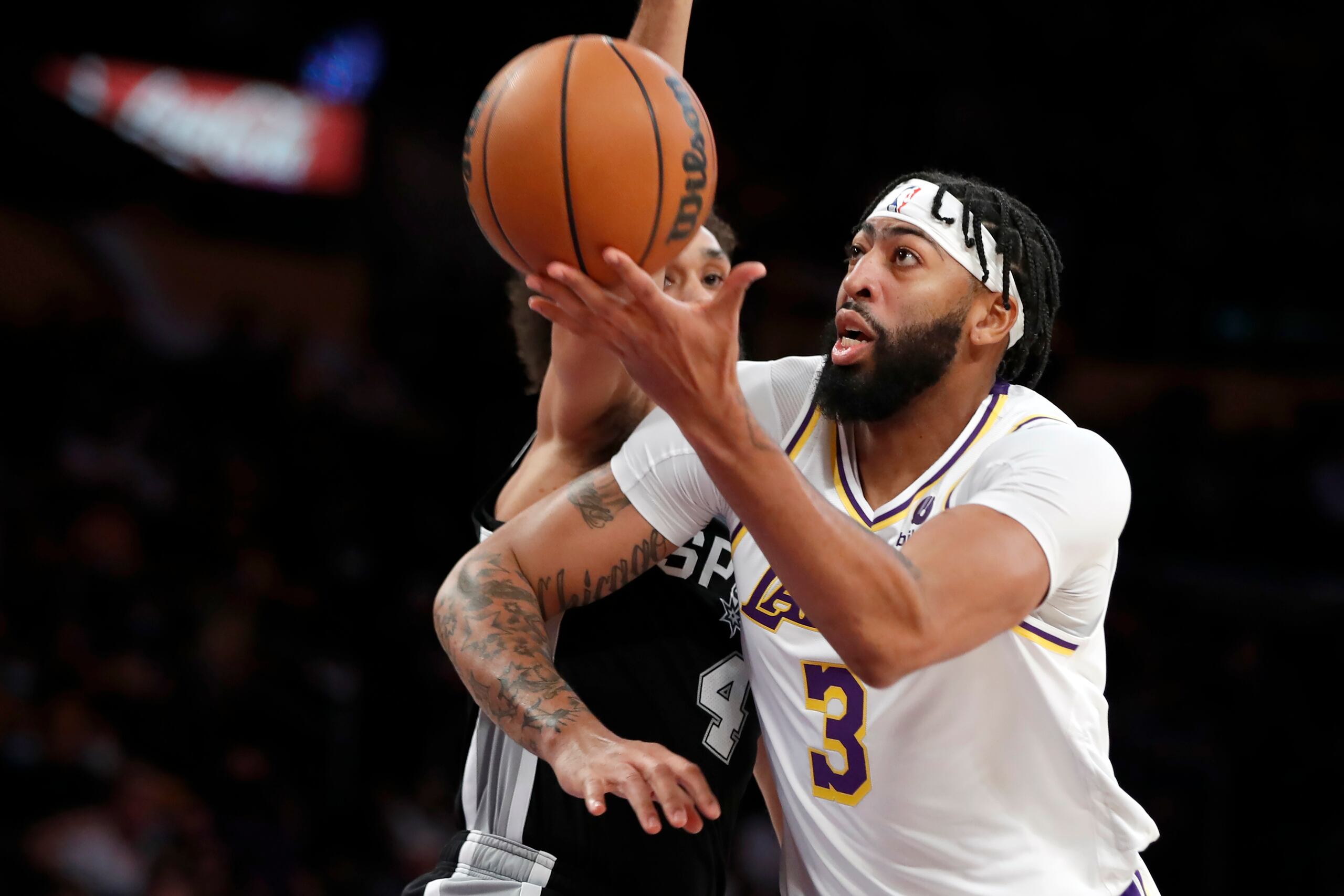 El delantero de los Lakers de Los Ángeles, Anthony Davis, supera al guardia de los Spurs de San Antonio, Derrick White, durante el juego de la NBA, el domingo 14 de noviembre de 2021, en Los Ángeles.