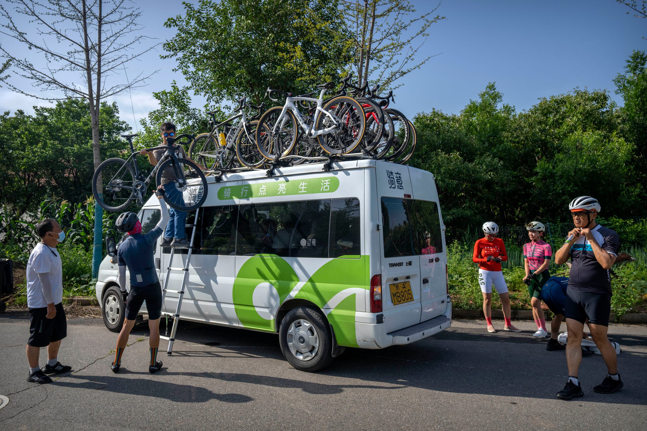 Ciclistas del club Qiyi descargan sus bicicletas para iniciar un recorrido por el Cañón del Río Baihe, en las afueras de Beijnig, el 13 de julio del 2022. (AP Photo/Mark Schiefelbein)