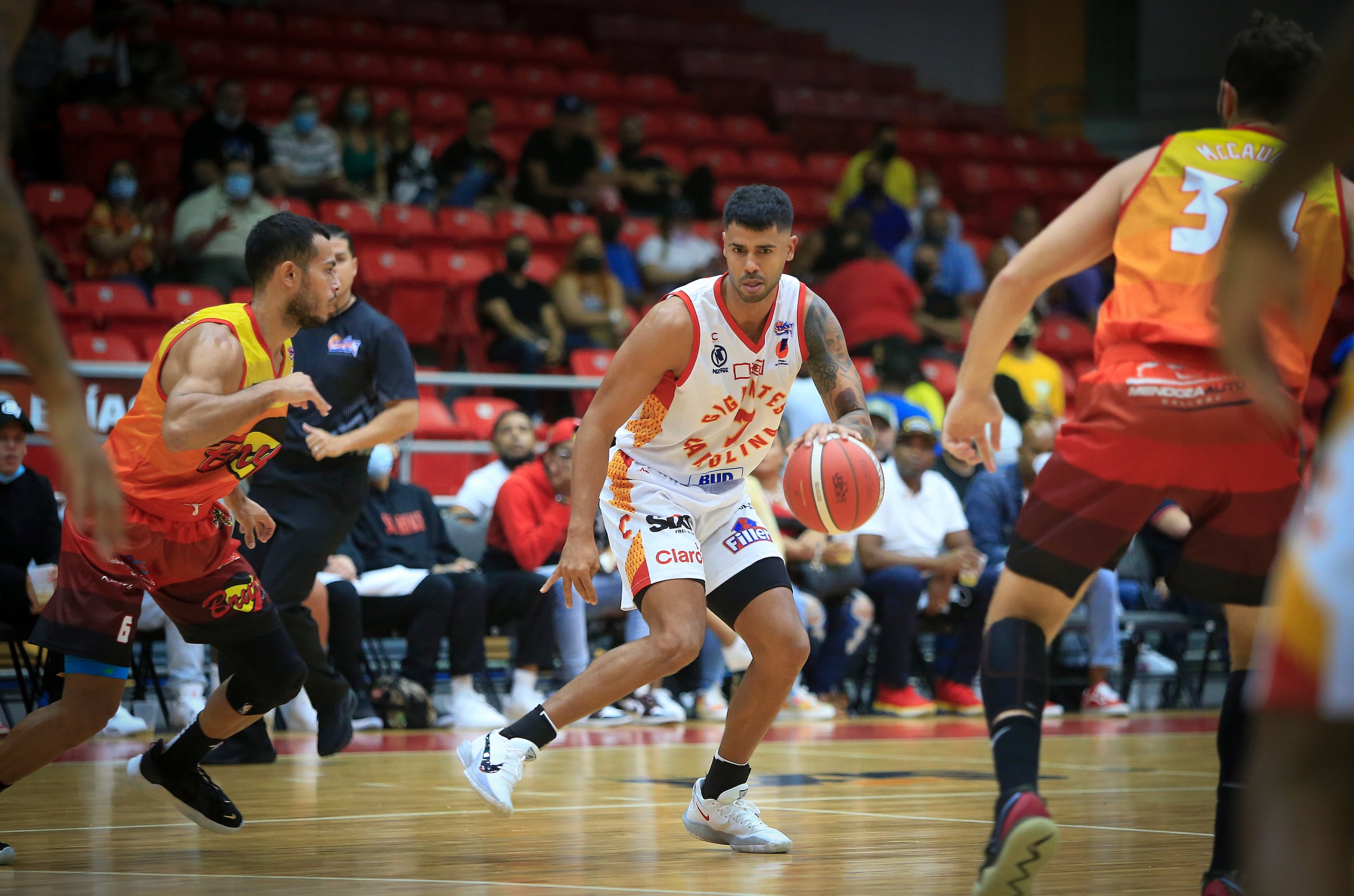 Alí Berdiel, de los Gigantes de Carolina, defiende el balón del acecho de Javier González, de los Brujos de Guayama.