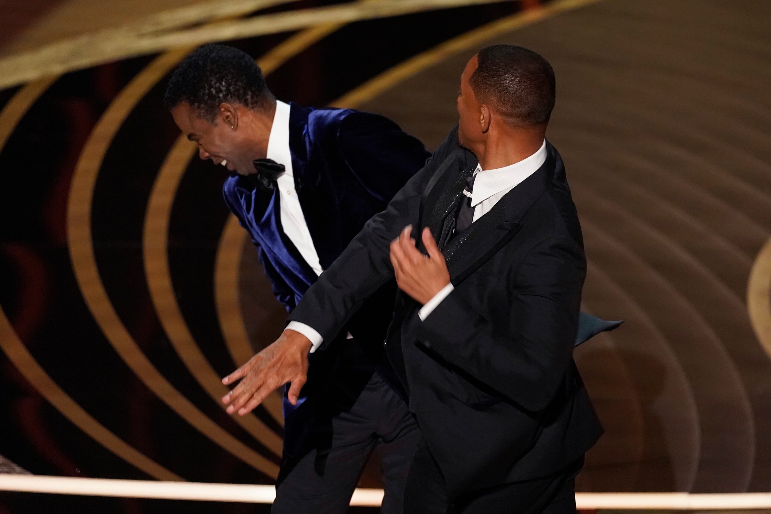 Will Smith, a la derecha, le pega al presentador Chris Rock en medio de la transmisión de los premios Oscar.