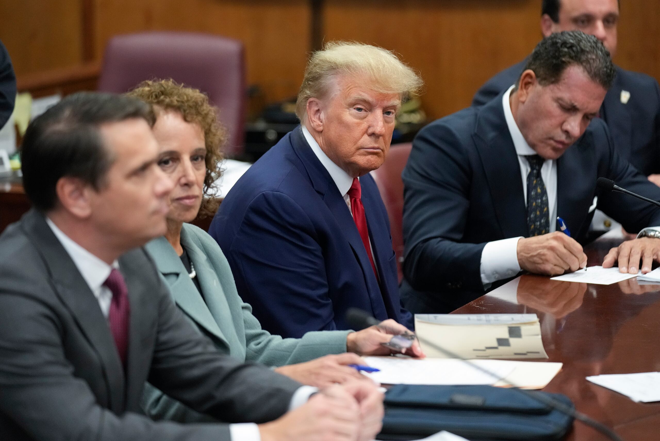 El expresidente Donald Trump junto a su equipo de defensa en un tribunal de Manhattan.