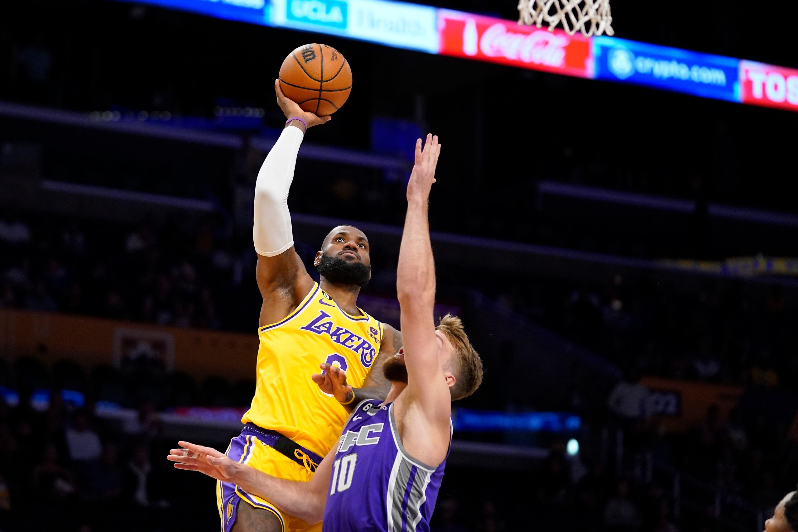 En foto del 3 de octubre del 2022, LeBron James, izquierda, de los Lakers de Los Ángeles, intenta encestar frente a Domantas Sabonis, de los Kings de Sacramento en Los Ángeles. El viernes 14 de octubre del 2022, LeBron James podría convertirse en el máximo anotador de la historia de la NBA esta temporada. El récord lo tiene Kareem Abdul-Jabbar desde 1984. (AP Foto/Mark J. Terrill)