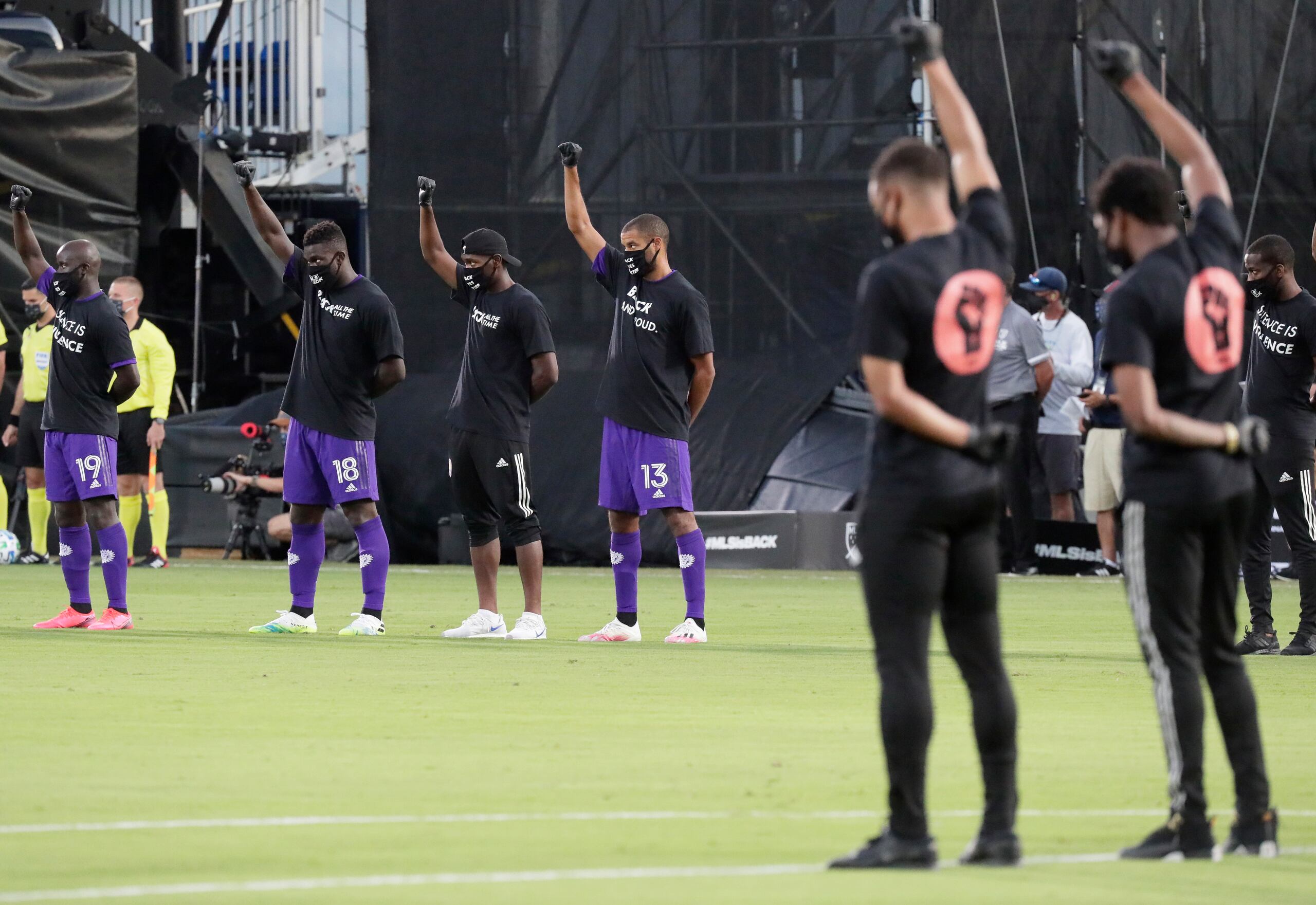 Jugadores del Orlando City (izquierda) levantan un puño como una protesta contra la injusticia social antes de poner en marcha un torneo que marca la reanudación de la actividad en la MLS, interrumpida por la pandemia de coronavirus.