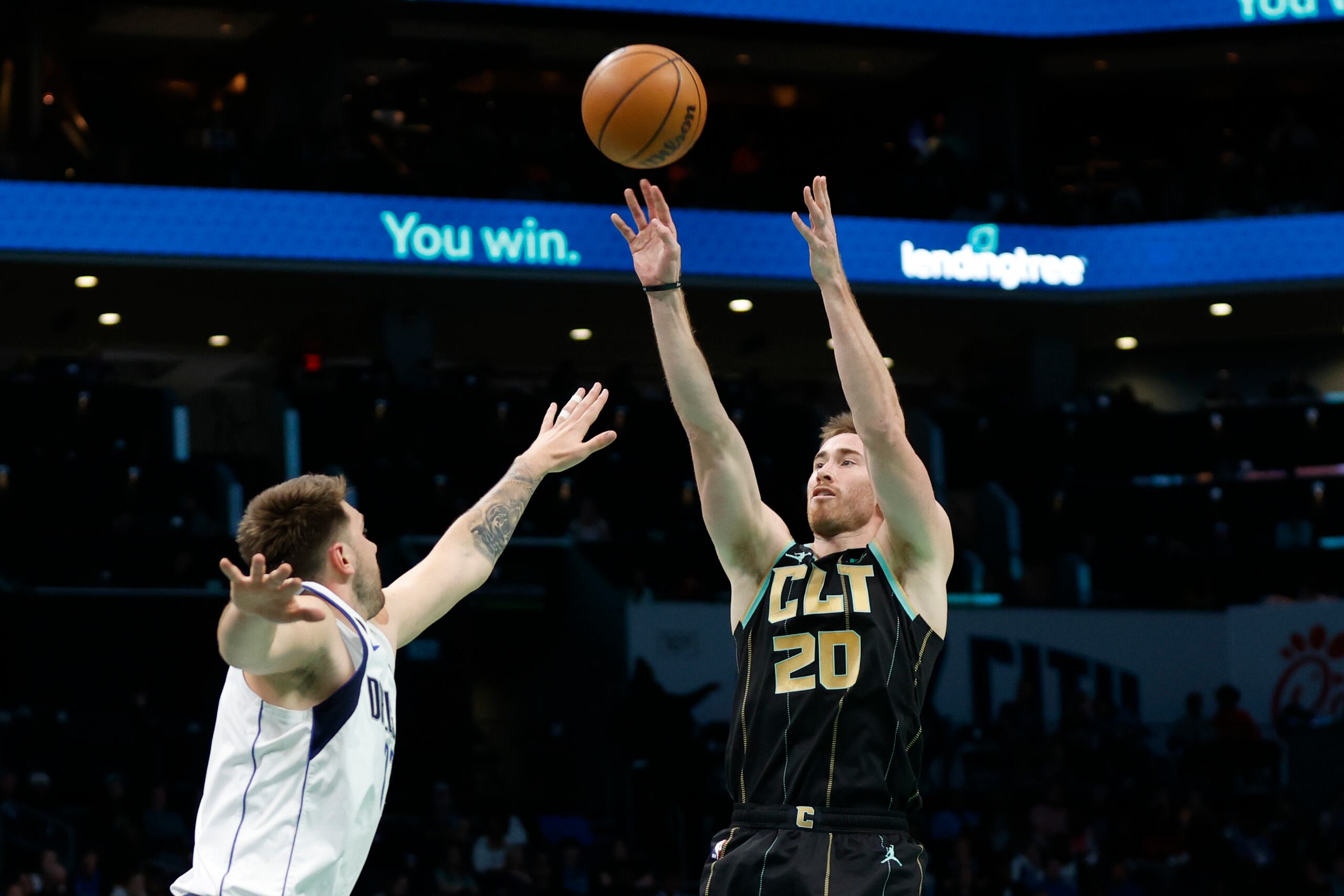 El alero de los Hornets de Charlotte Gordon Hayward lanza el balón sobre el base de los Mavericks de Dallas Luka Doncic en el encuentro del domingo 26 de marzo del 2023. (AP Foto/Nell Redmond)