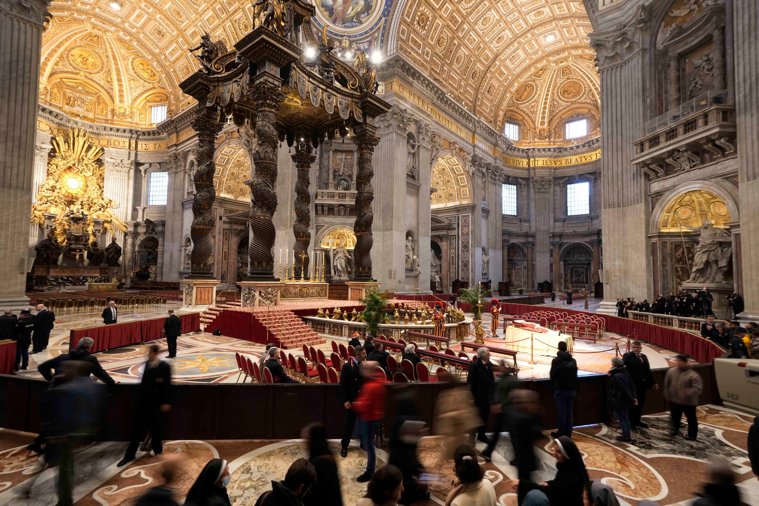 People look at the body of late Pope Emeritus Benedict XVI laid out in state inside St. Peter's Basilica at The Vatican, Monday, Jan. 2, 2023. Benedict XVI, the German theologian who will be remembered as the first pope in 600 years to resign, has died, the Vatican announced Saturday. He was 95. (AP Photo/Andrew Medichini)