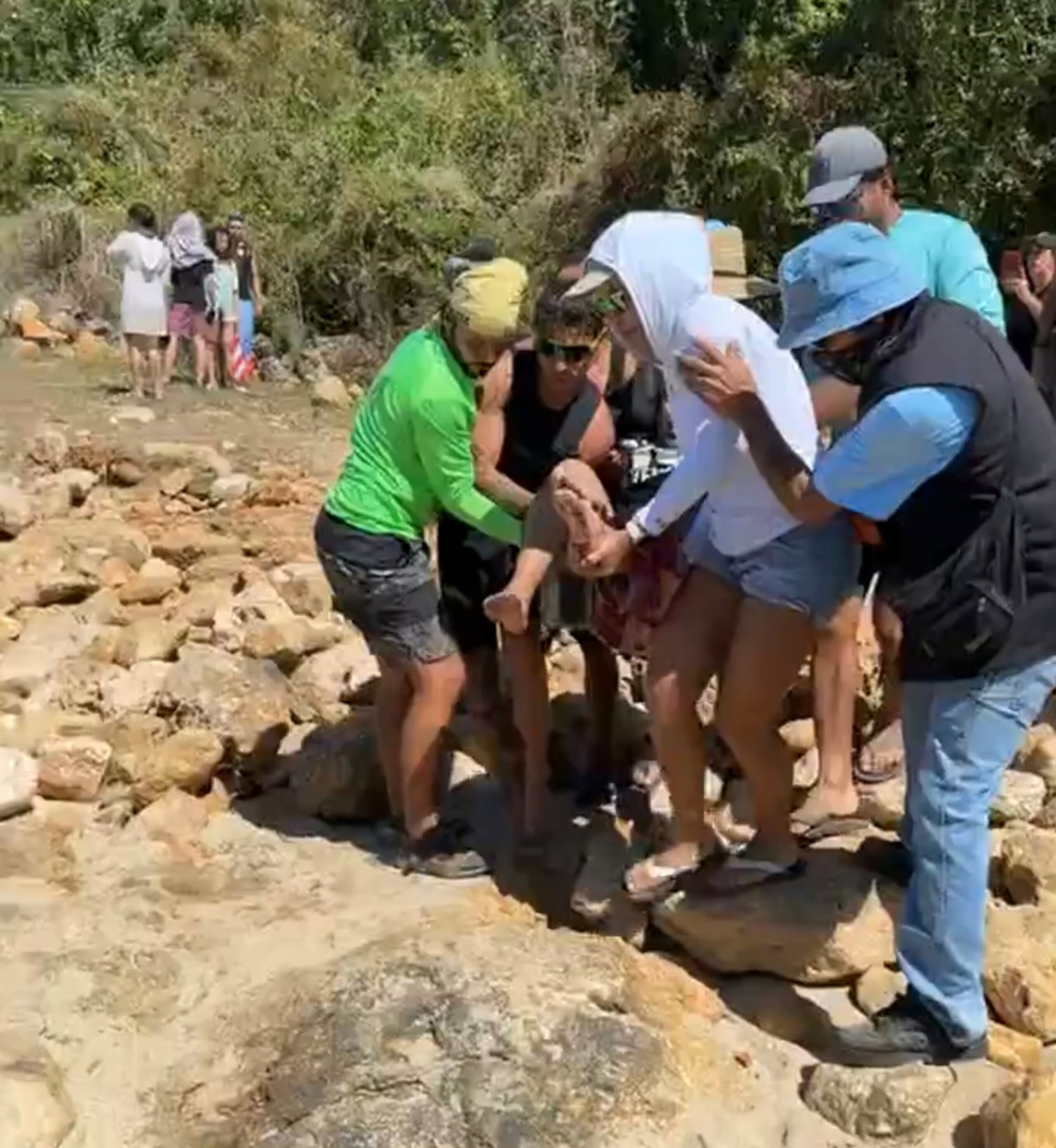 Varias personas cargan a un herido en el área del muelle de Azúcar en Aguadilla.