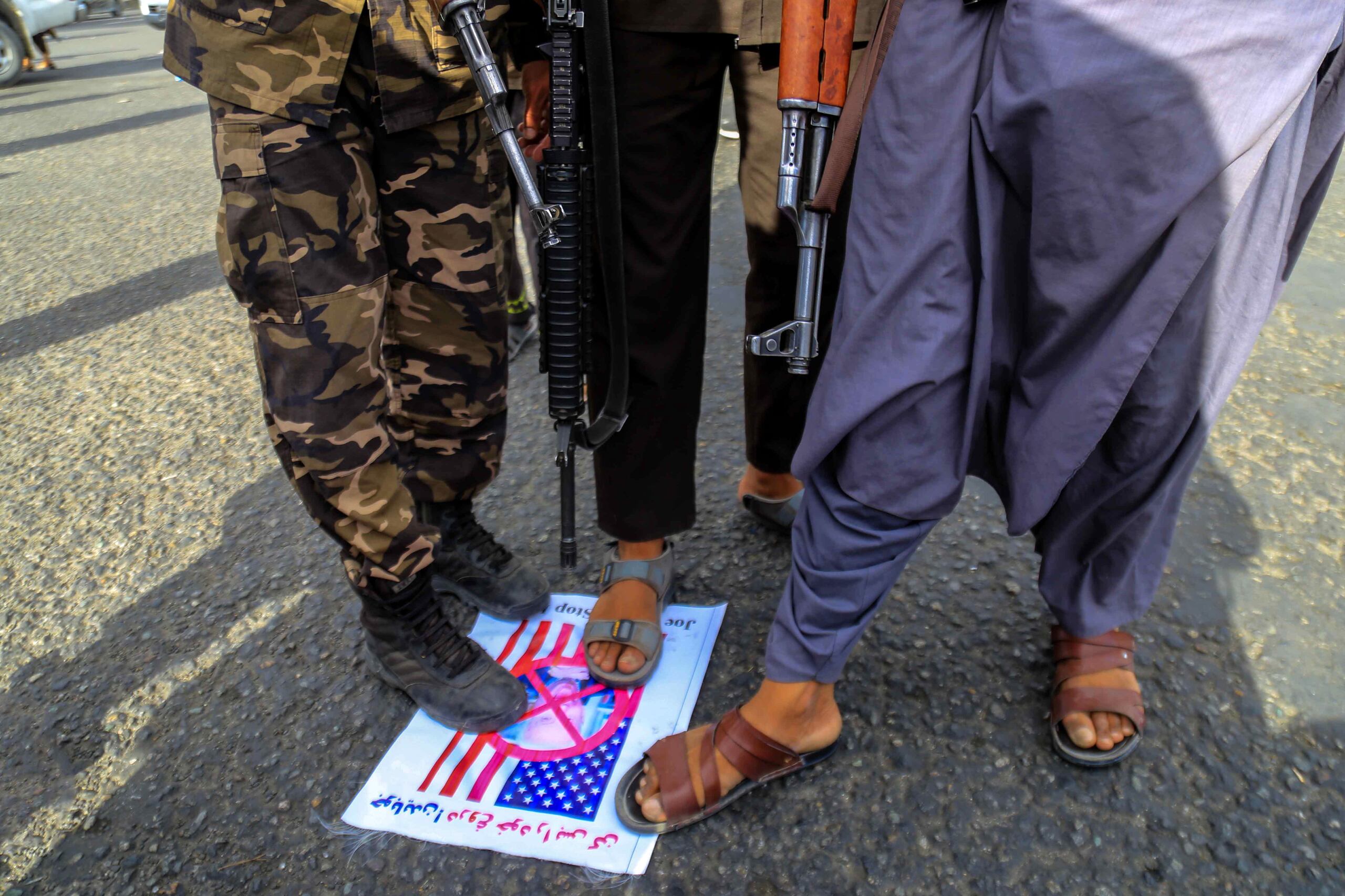 Imagen de archivo en la que se ve a unos talibanes pisando una foto del presidente estadounidense, Joe Biden, en Kabul el pasado 5 de agosto. EFE/EPA/STRINGER
