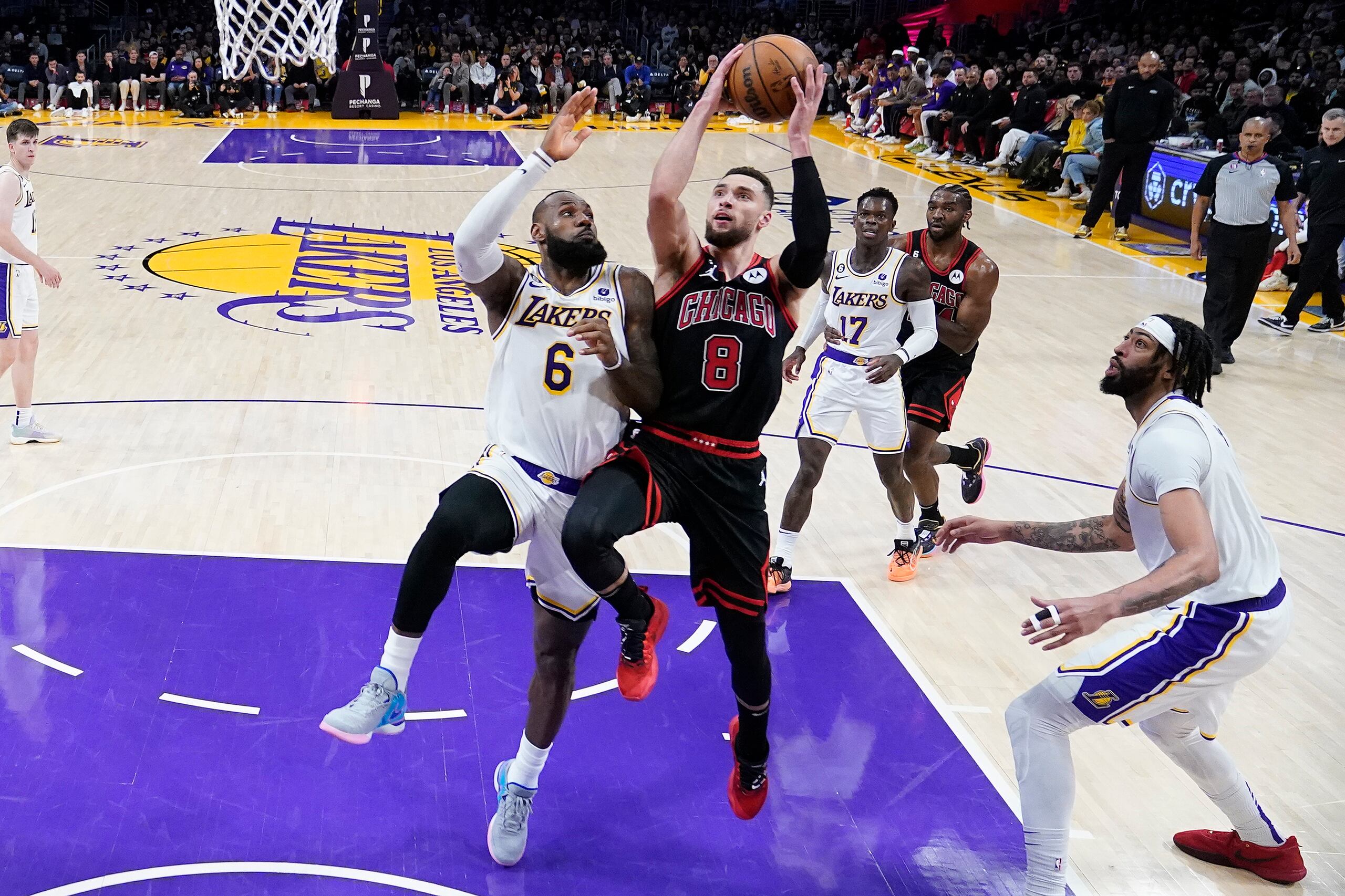 Zach LaVine (8), de los Bulls de Chicago, ataca la canasta entre LeBron James, izquierda, y Anthony Davis, de los Lakers de Los Ángeles, durante la segunda mitad del juego de baloncesto de la NBA, el domingo 26 de marzo de 2023, en Los Ángeles. (AP Foto/Marcio Jose Sanchez)