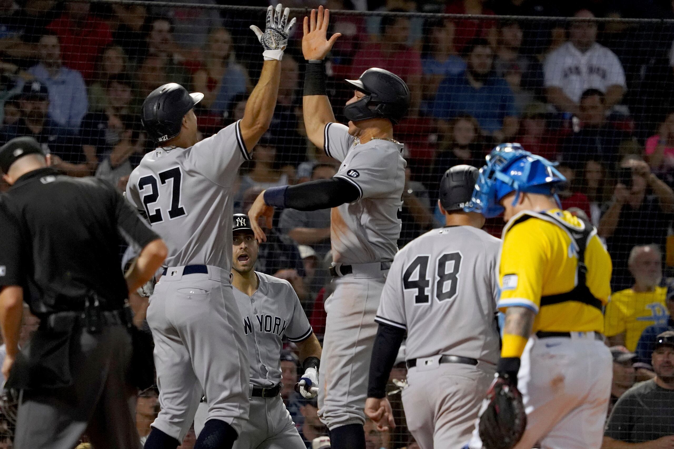 El bateador designado de los Yankees de Nueva York, Giancarlo Stanton (27), celebra con Aaron Judge tras disparar un bambinazo de tres carreras durante la tercera entrada del partido del viernes en el Fenway Park de Boston.