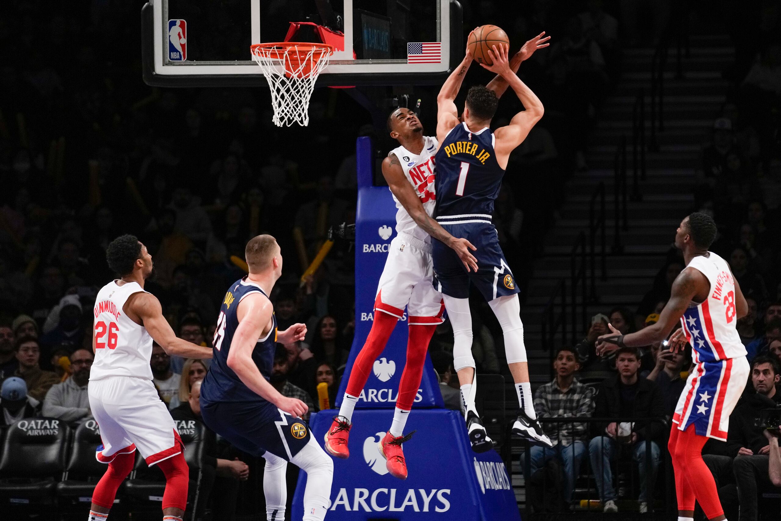 Nic Claxton, arriba a la izquierda, comete falta a Michael Porter Jr. (1), de los Nuggets de Denver, durante la segunda mitad del juego de baloncesto de la NBA, el domingo 19 de marzo de 2023, en Nueva York. Los Nuggets derrotaron a los Nets 108-102. (AP Foto/Seth Wenig)