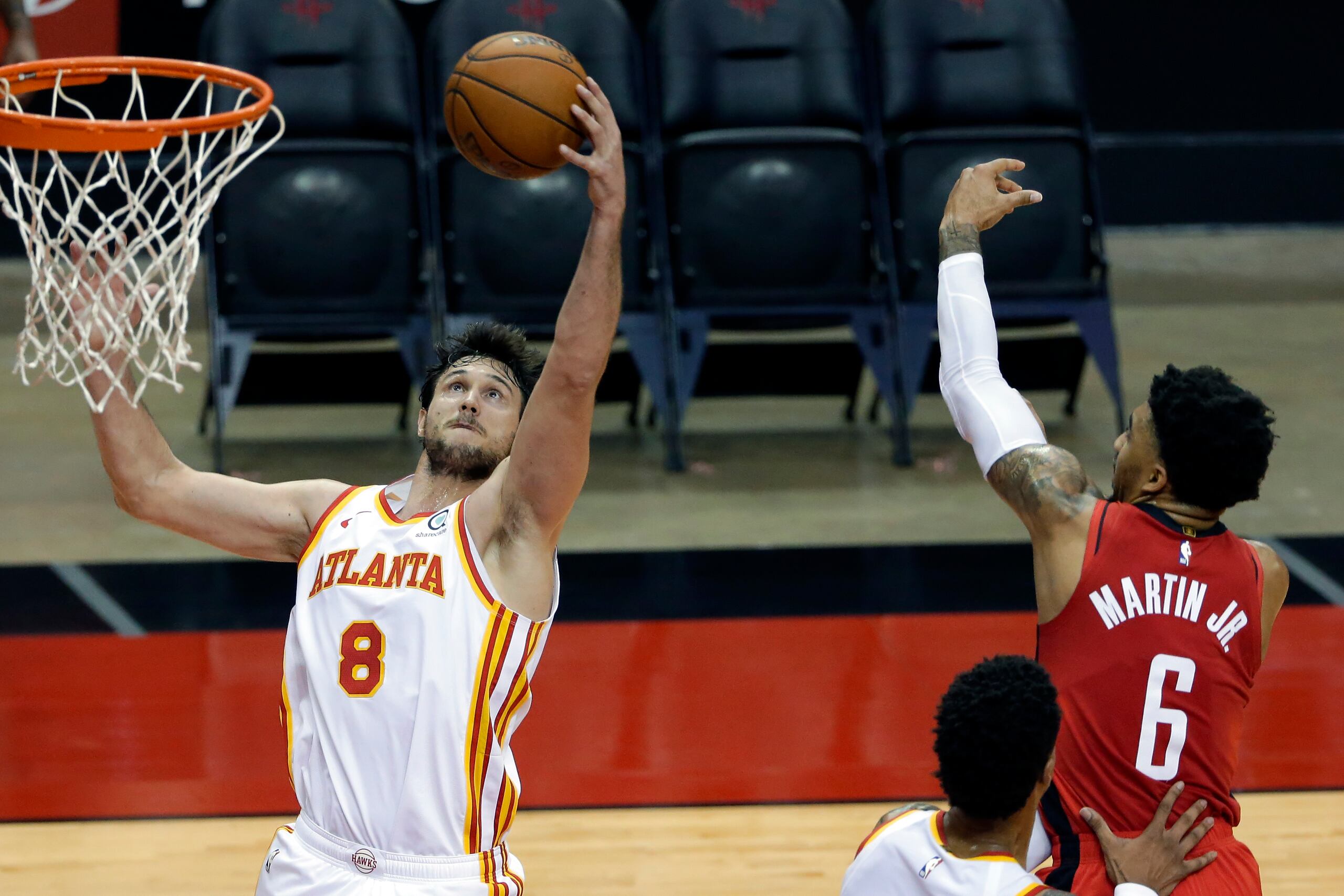 Danilo Gallinari (8) atrapa un rebote Kenyon Martin Jr. (6) en el encuentro entre los Hawks y los Rockets.