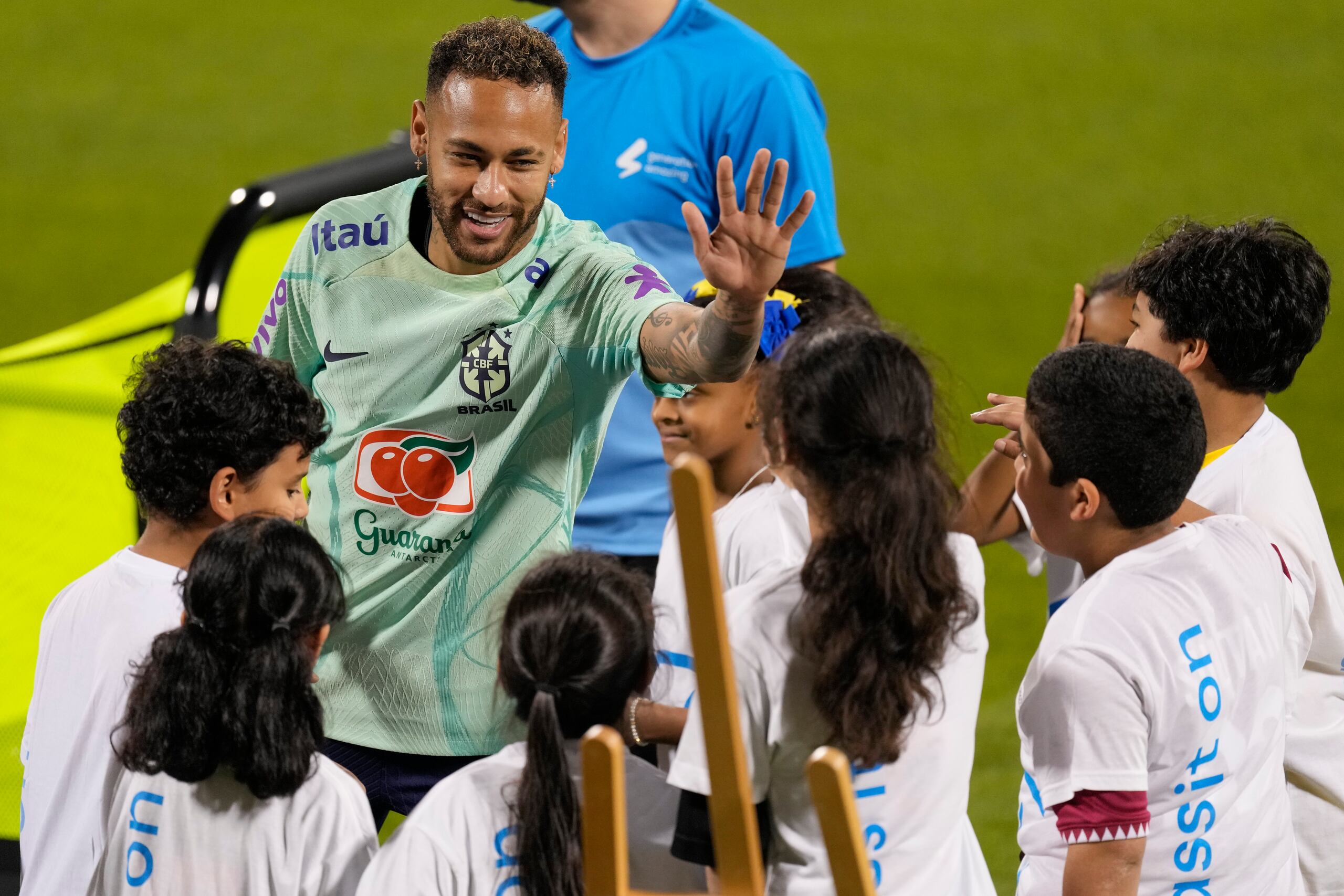 Neymar saluda a niños de un proyecto de la FIFA en un entrenamiento en el estadio Grand Hamad en Doha, Qatar.