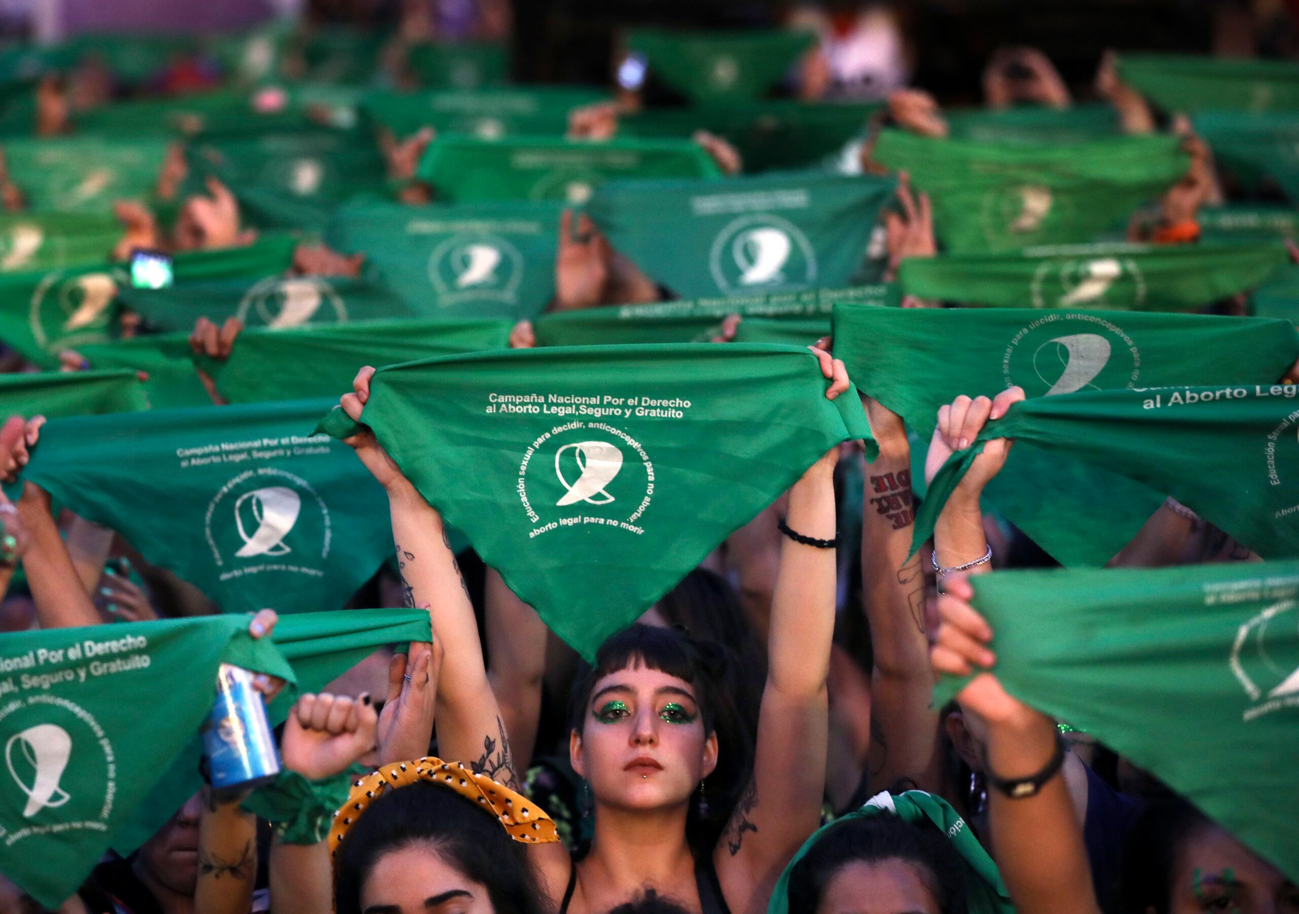 Activistas levantan el emblemático pañuelo verde en favor del derecho de las mujeres a decidir sobre sus cuerpos.